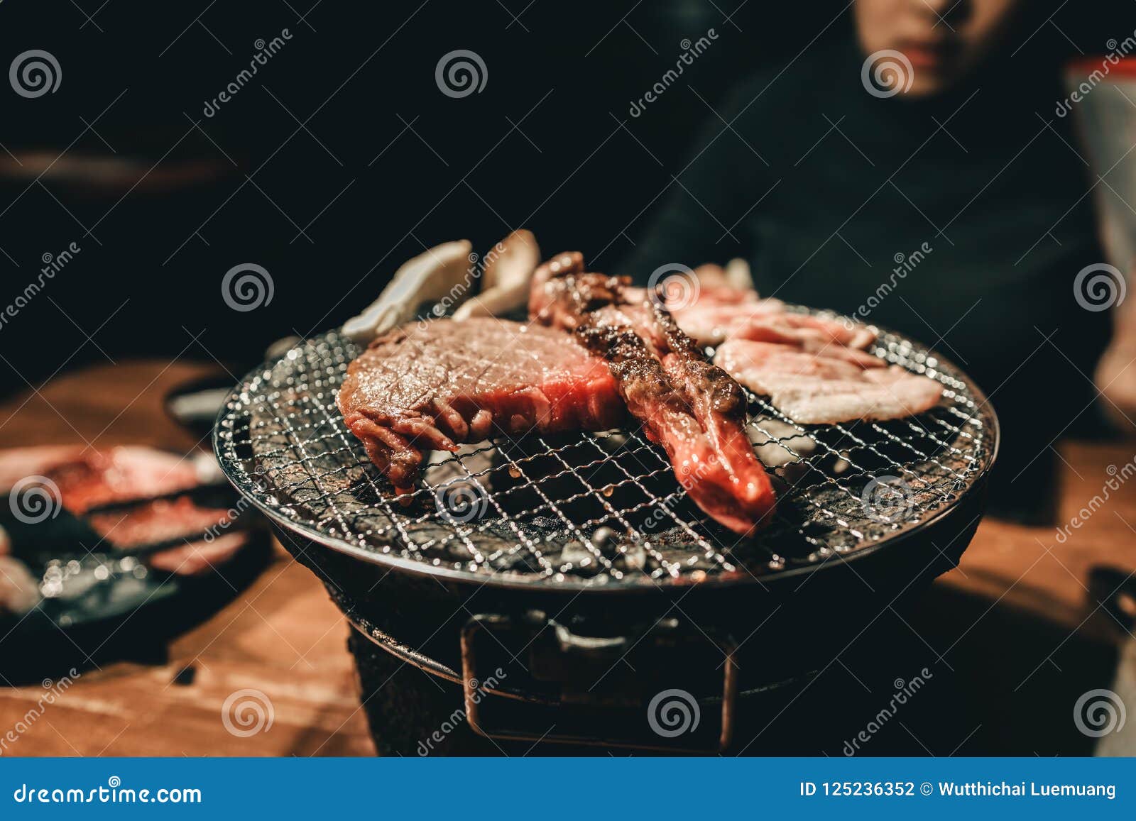 Close Pork Meat on a Charcoal Grill in Restaurant. Stock Photo Image
