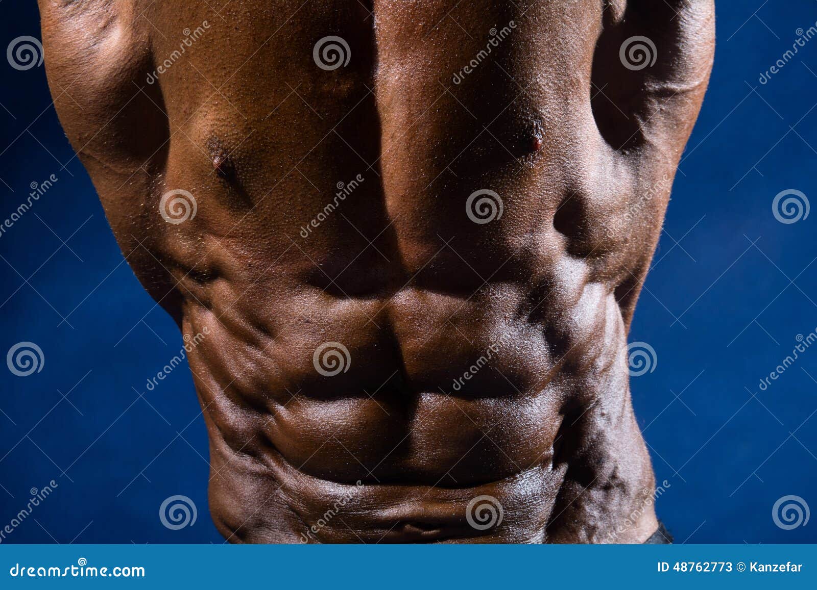Closeup of Abdominal Muscles Bodybuilder on a Blue Background Stock