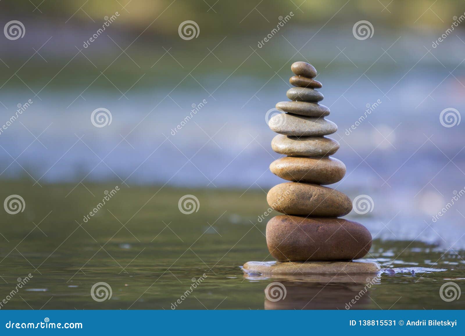 close-up abstract image of wet rough natural brown uneven different sizes and forms stones balanced like pyramid pile landmark in