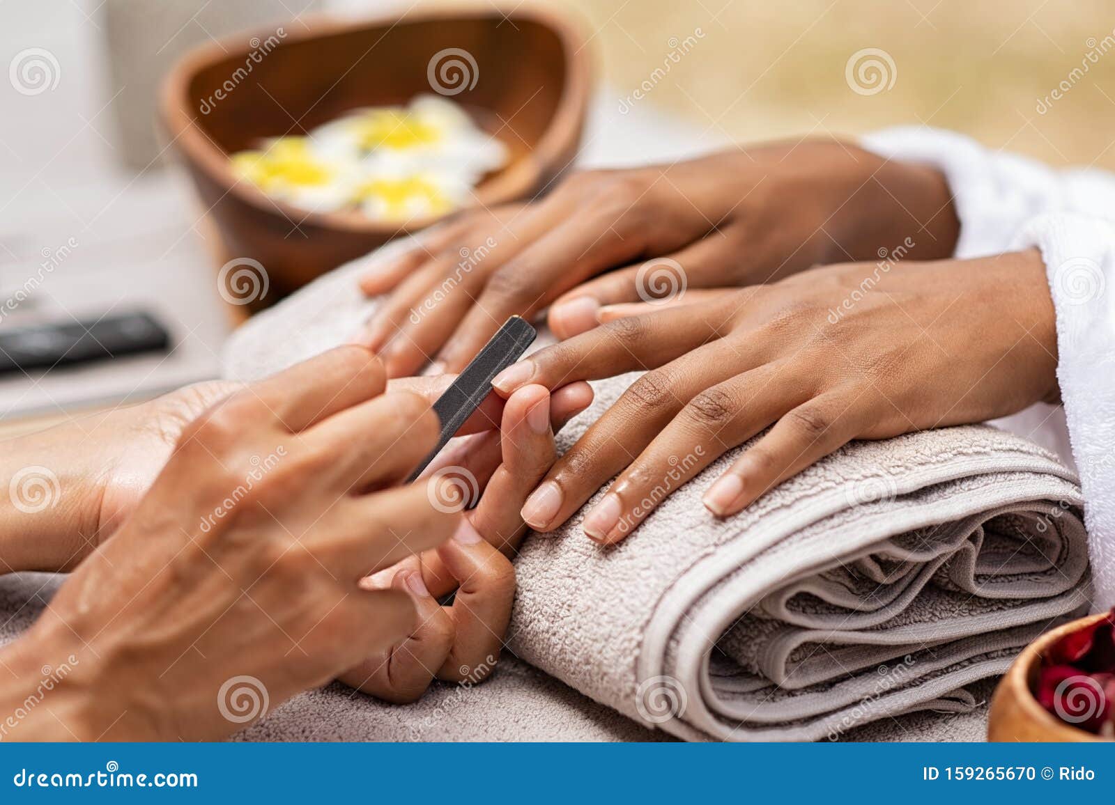 beautician file nails to a black hand