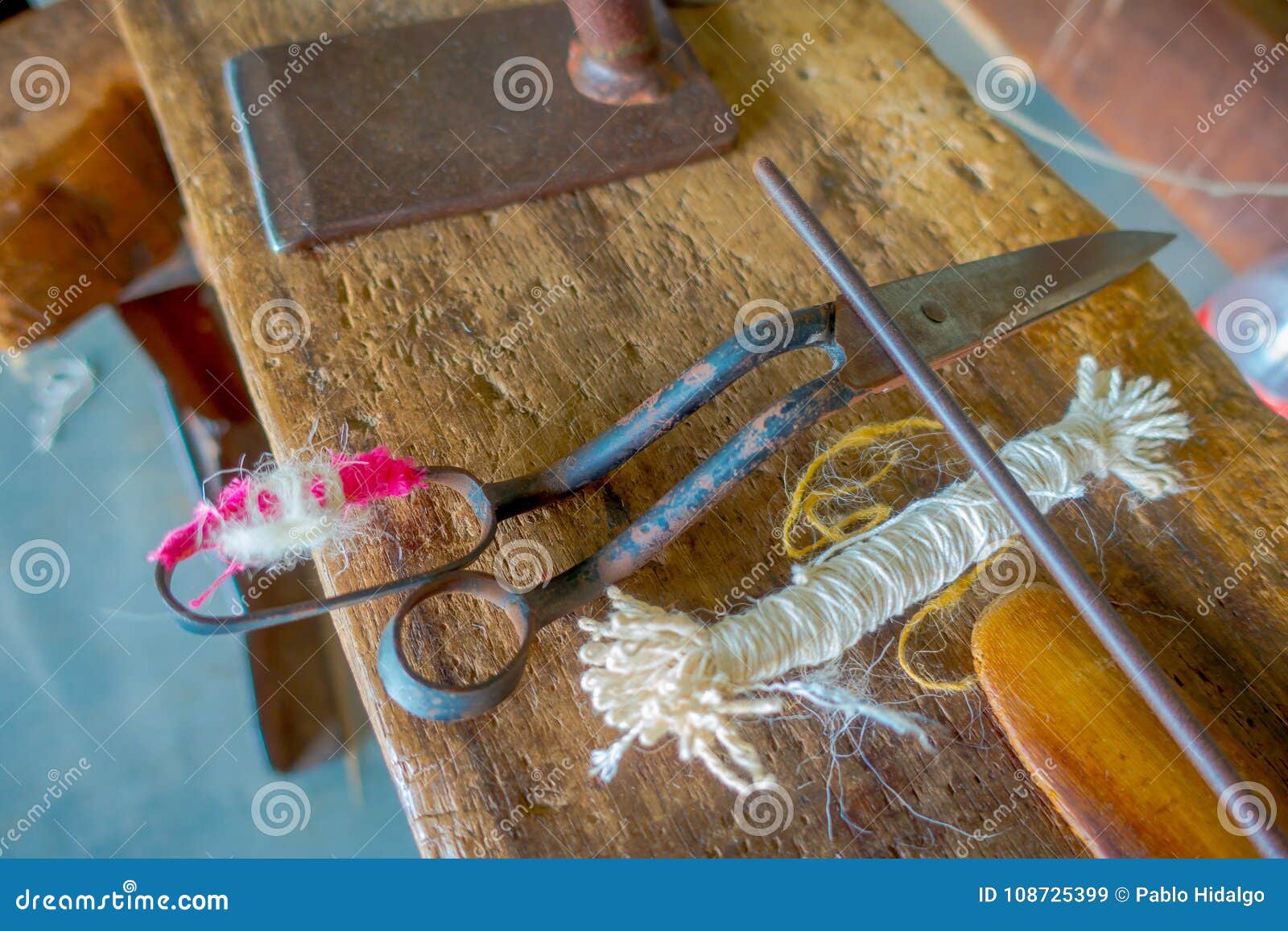 close up of assorted materials, whool and scissors to work on loom manufacturing wool shawl clothing in nepal