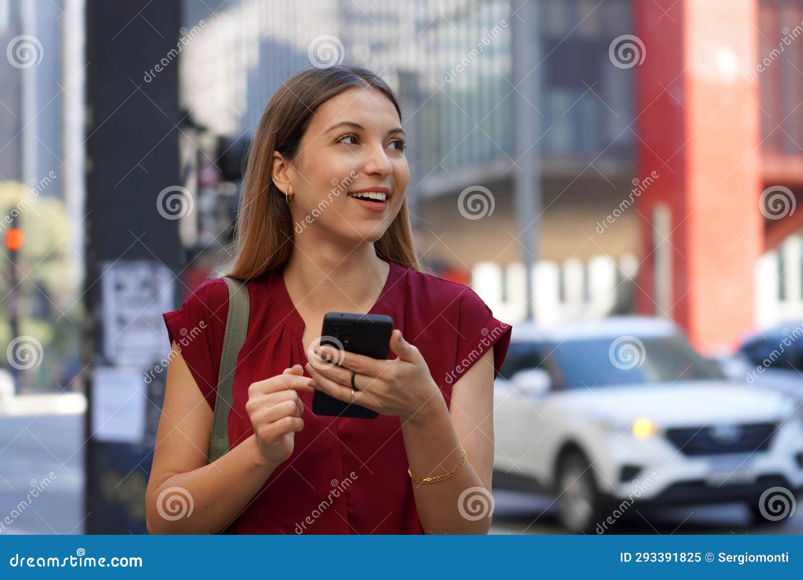 close-up of attractive brazilian business woman hail a vehicle using mobile app looking to the side on paulista avenue, sao paulo