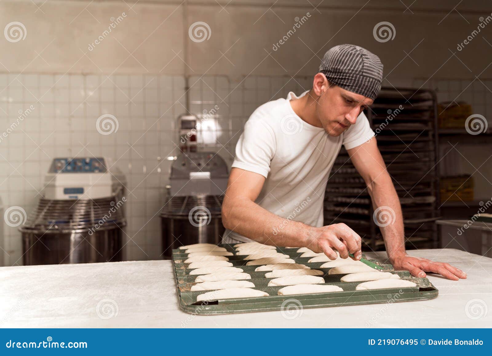 Close Up of Baker Cutting and Decorating Fresh Bread Dough before Baking it in the Oven