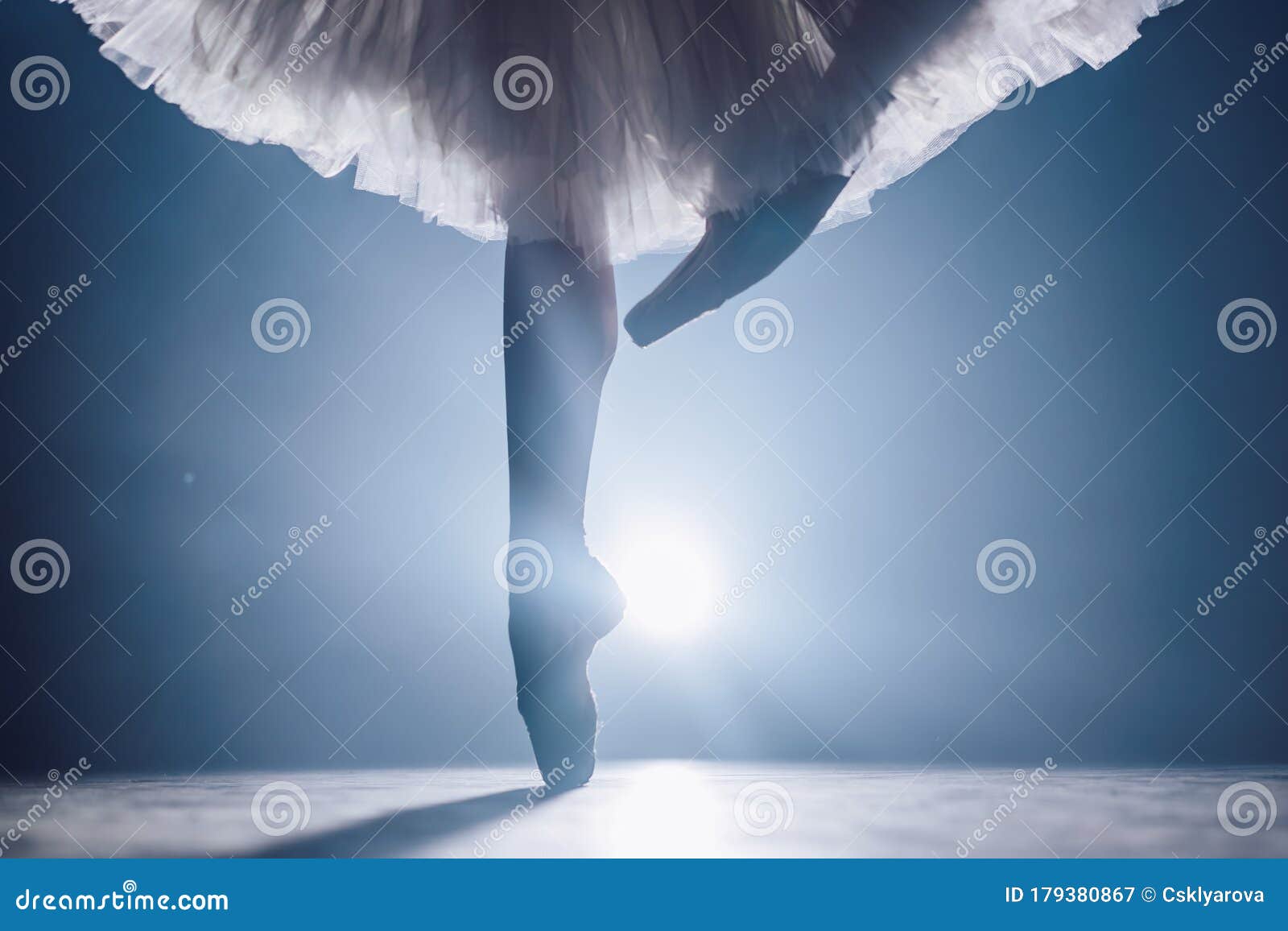 Close Up Of Ballet Dancer As She Practices Exercises On Dark Stage Or