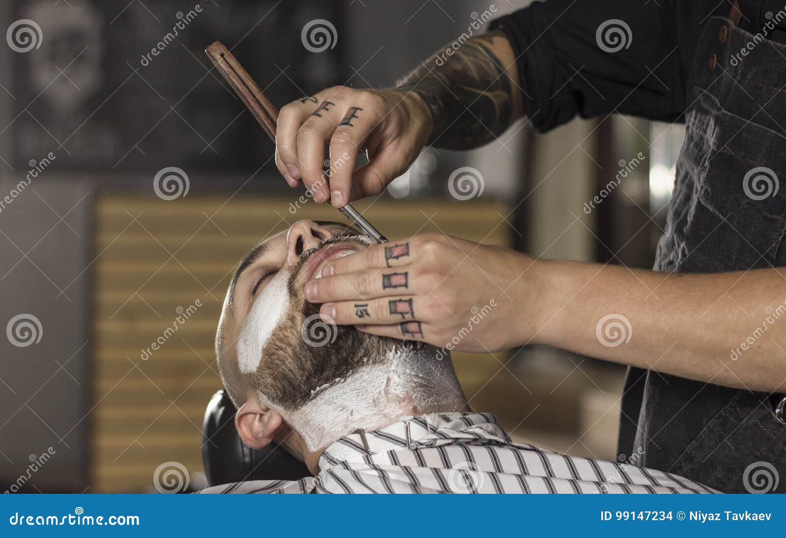 CLose Up of Barber Shaving Client Using Old Fashioned Razor Stock Photo
