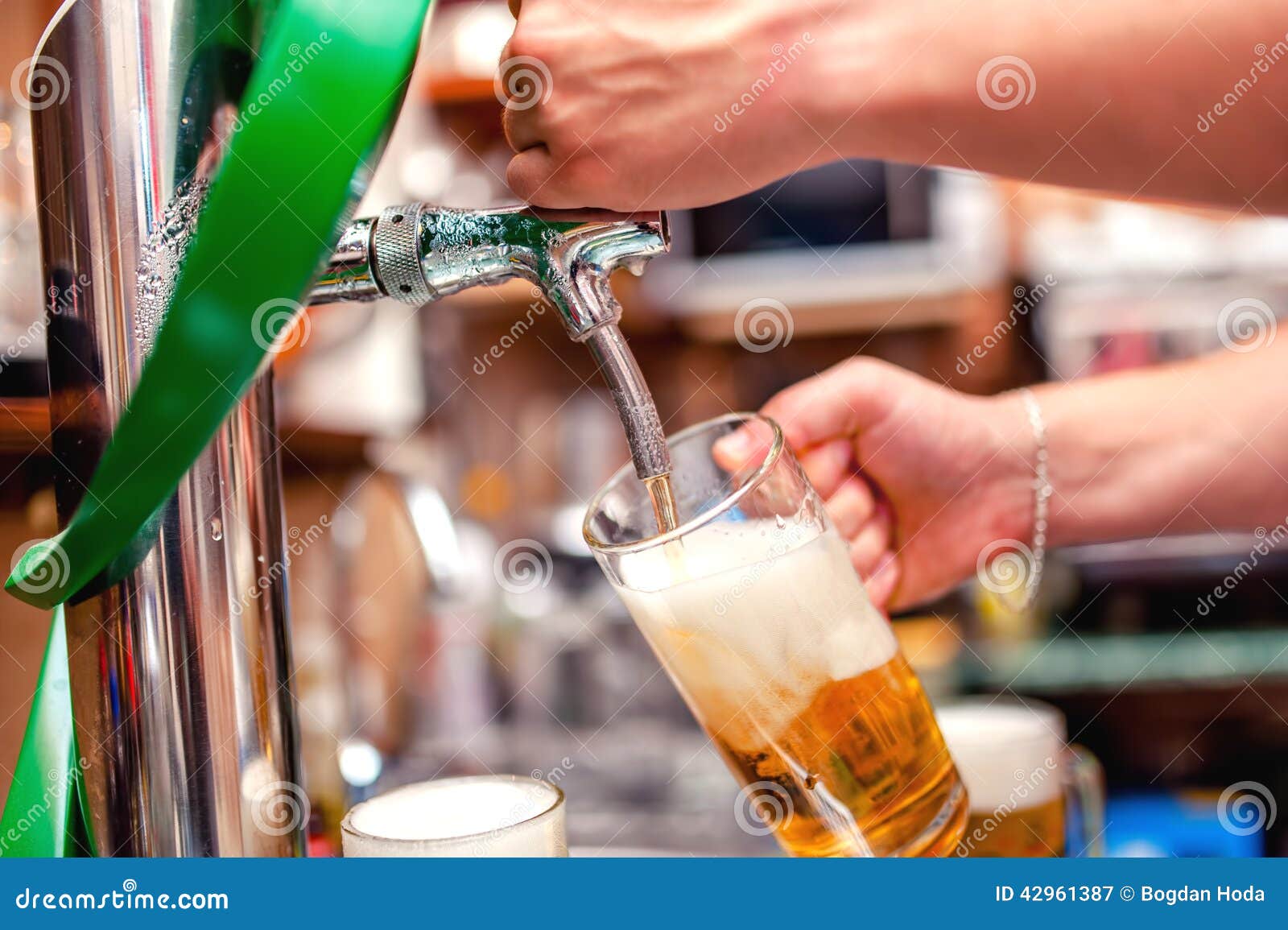 close-up of barman brewing a draft beer at pub. bartender pourin