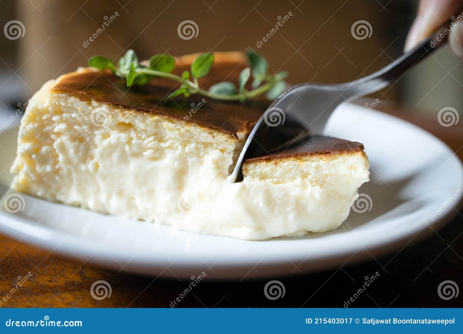 close up,basque burnt cheesecake,tarta de queso or san sebastian cheesecake on a white plate with a spoon to scoop the soft cheese