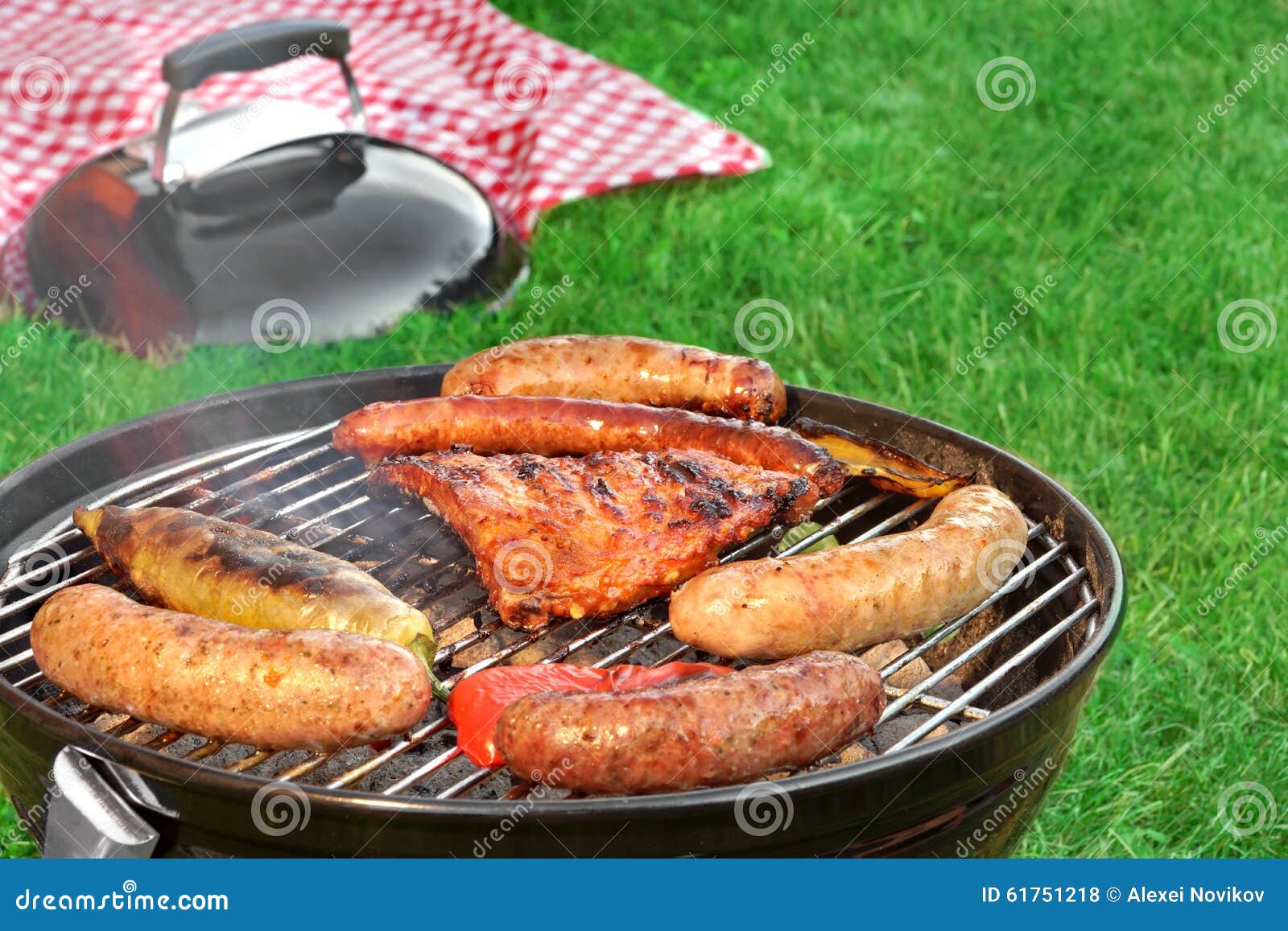 close-up of bbq grill and picnic blanket in the background