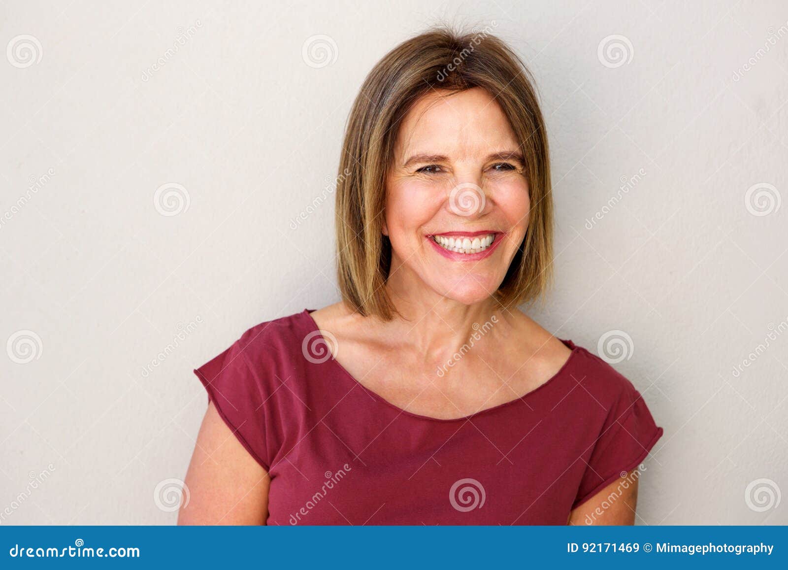 close up beautiful middle age woman smiling against white wall