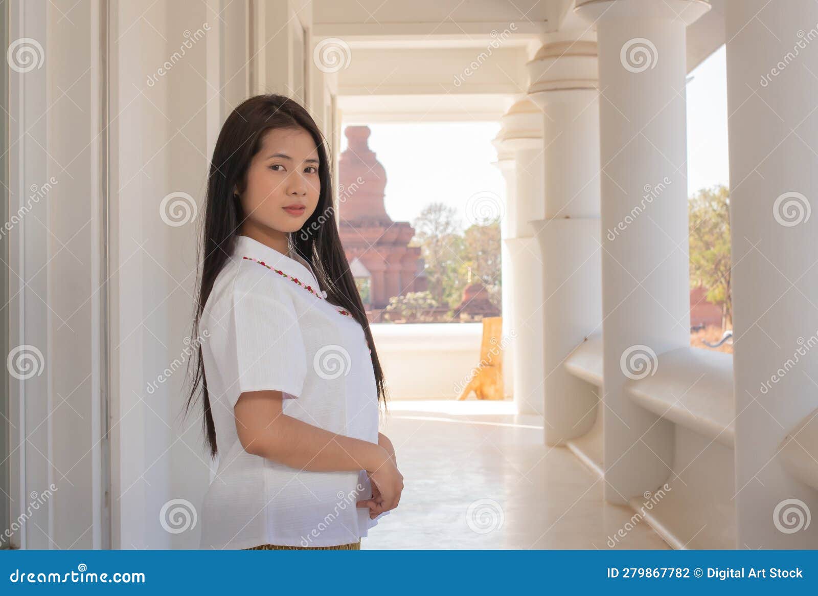 close up of beautiful thai woman in a white traditional thai dress is standing in white temple with smilingly face