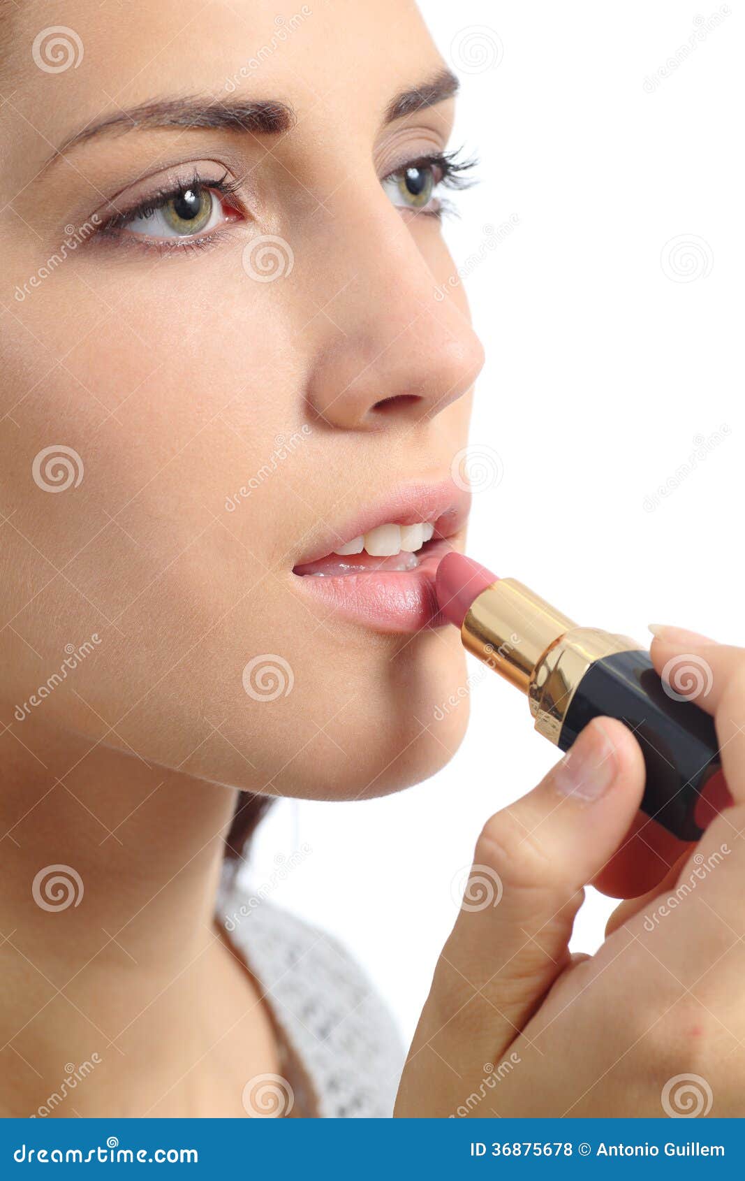 close up of a beautiful woman applying a lipstick on lips