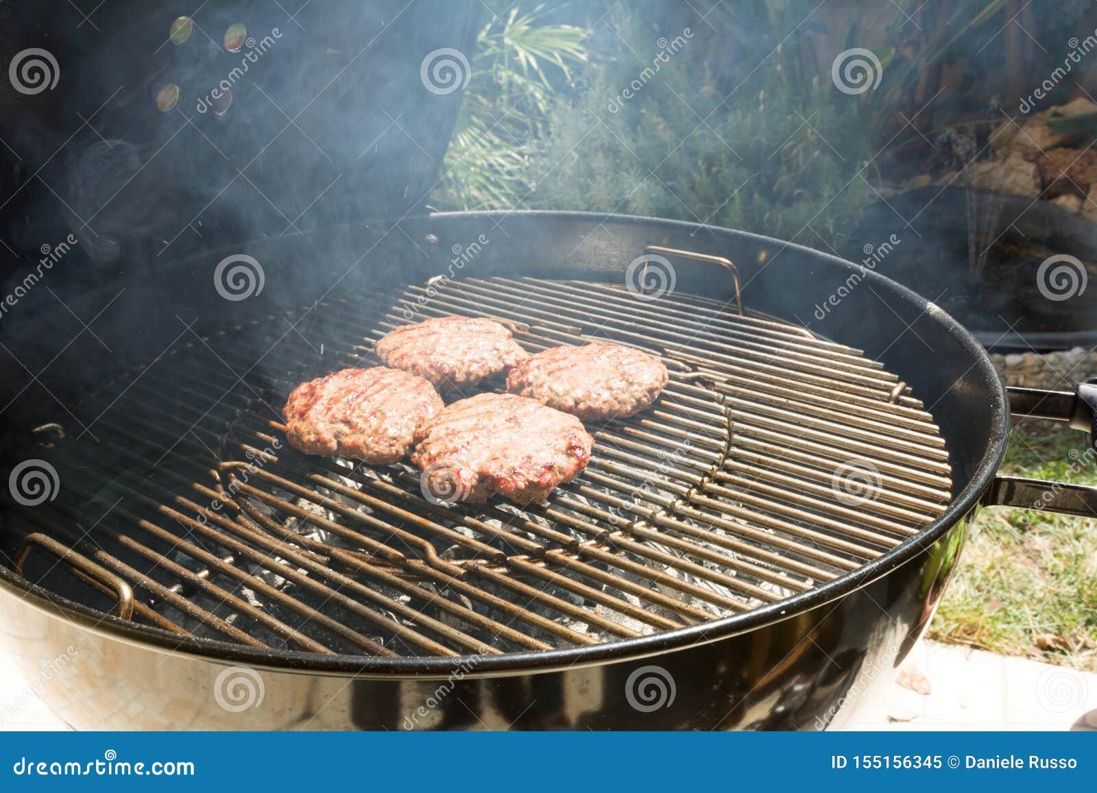 Close Up of Beef Hamburger Cooking on a Charcoal Grill Stock Image