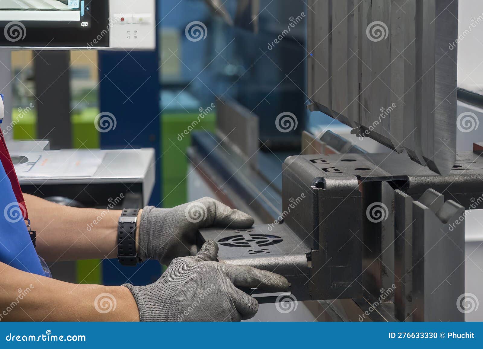 close up the bending machine operator hold the sheet metal parts and wear safety glove