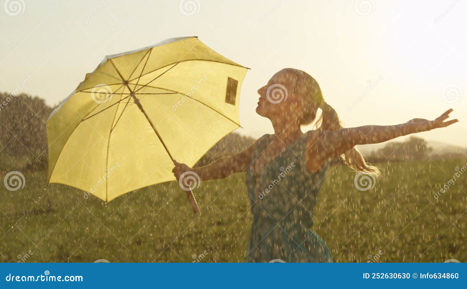 close up: blonde haired woman dances in the picturesque golden lit countryside.