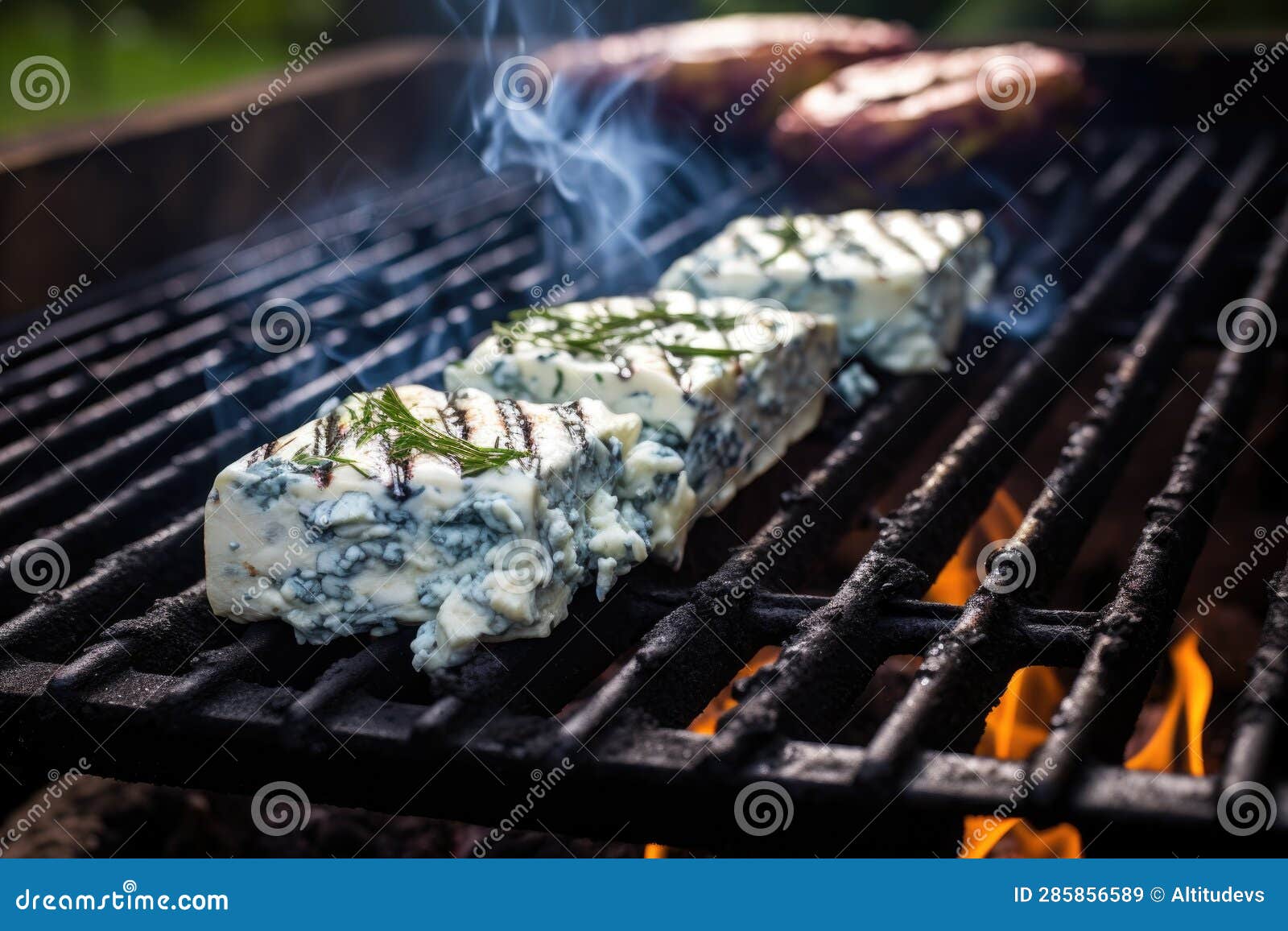 Closeup of Blue Cheese Melting on Cedar Plank Over Grill Stock Image
