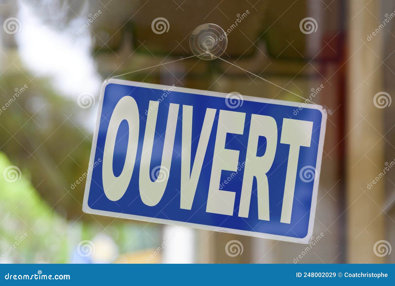 Red and blue sign in the window of a shop saying in French Ouvert, meaning  in English Open Stock Photo - Alamy