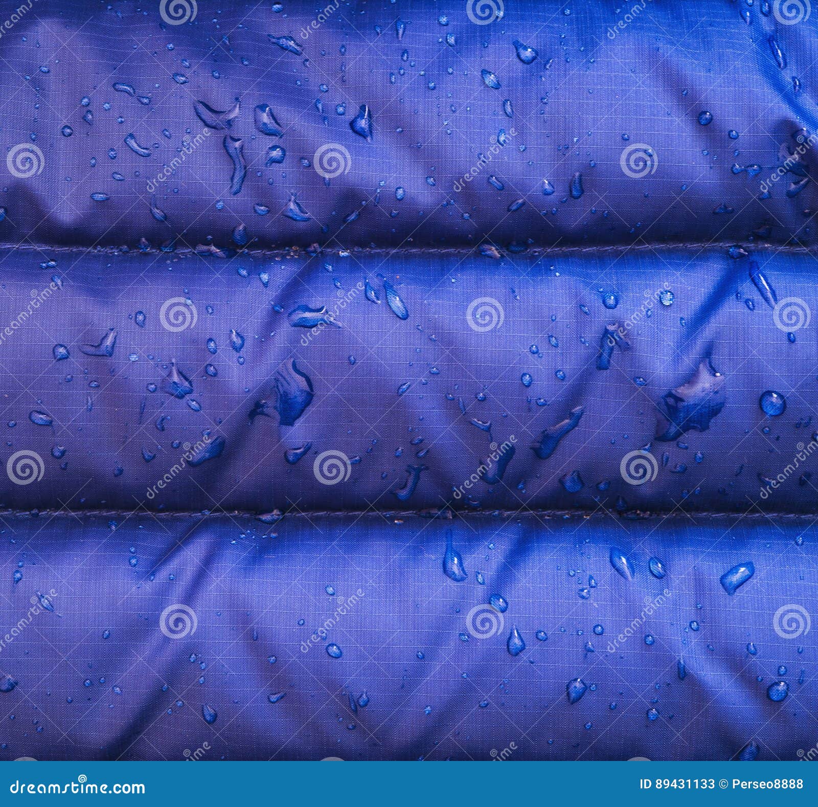 A Close Up of Blue Waterproof Rain Jacket Fabric with Water Droplets