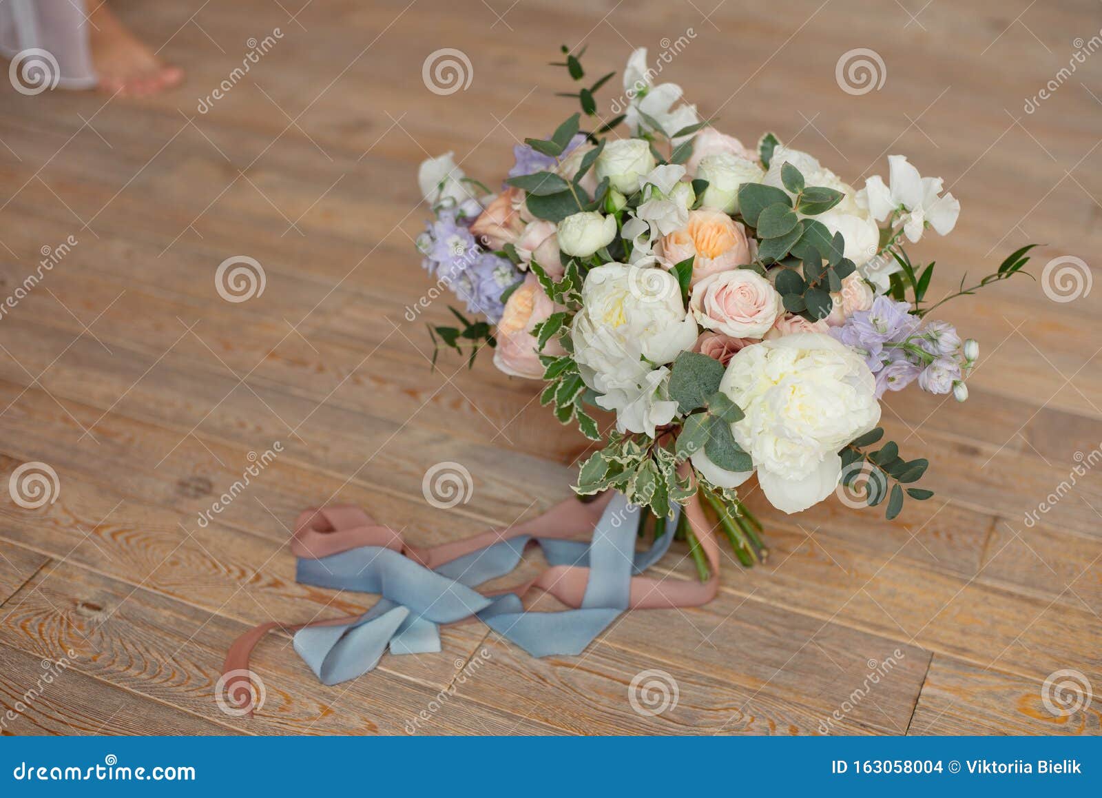 close-up bouquet of roses peonies freesia dianthus flowers on the round white floore indoors