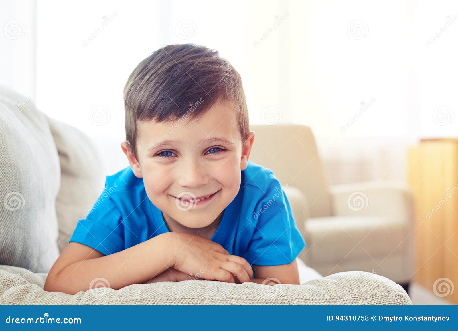 Closeup of Boy with Cornflower Blue Eyes Lying on Sofa Stock Photo
