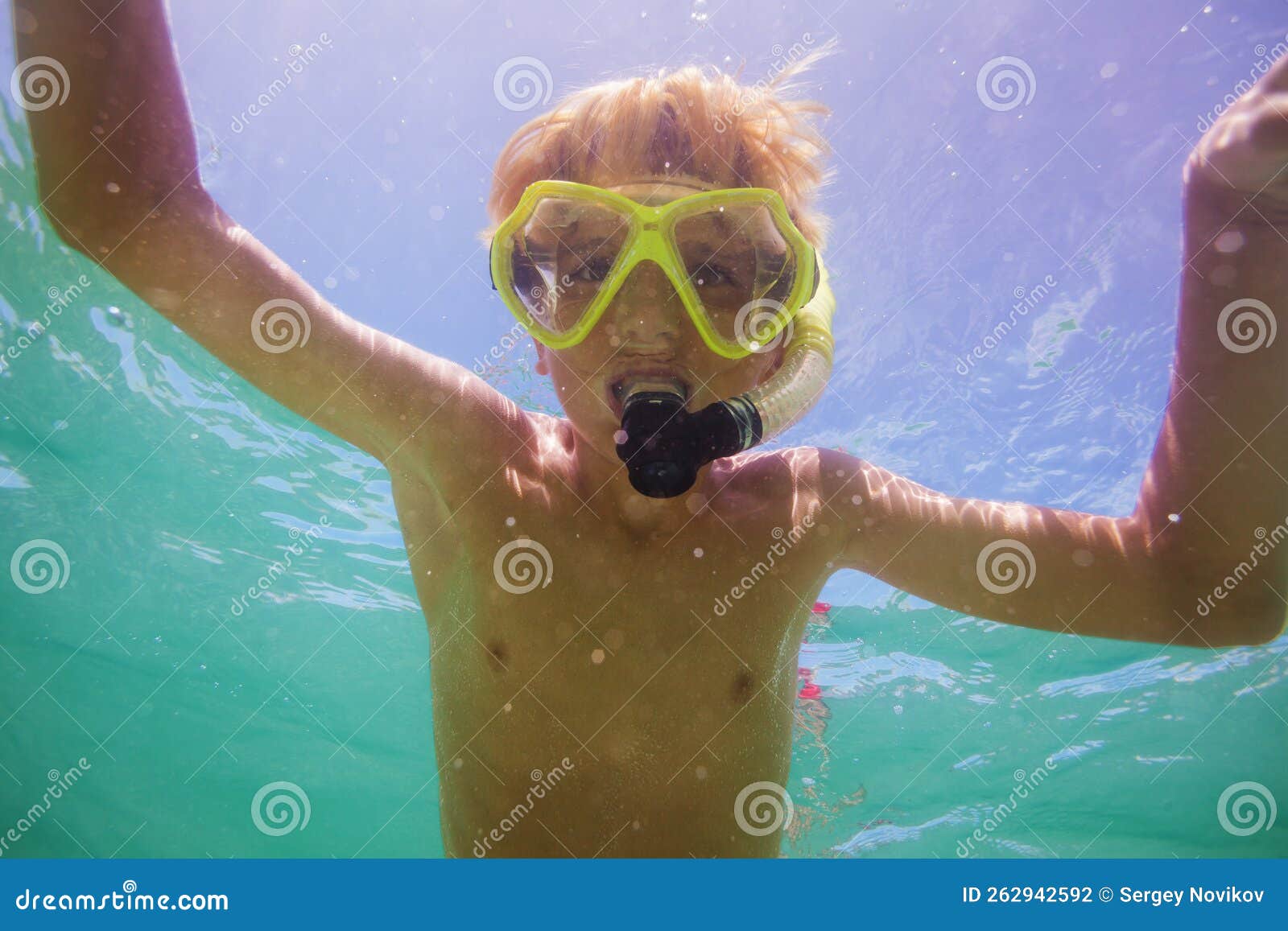 Closeup of Boy Swim in Ocean from Below Posing Underwater Stock Photo