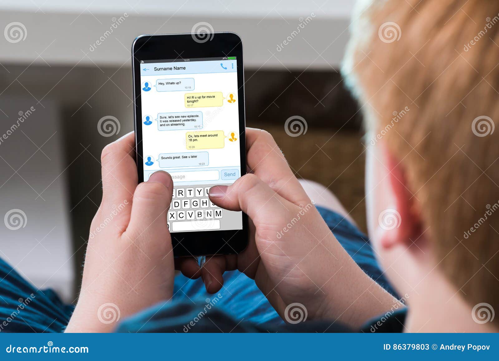 boy typing text message on mobile phone