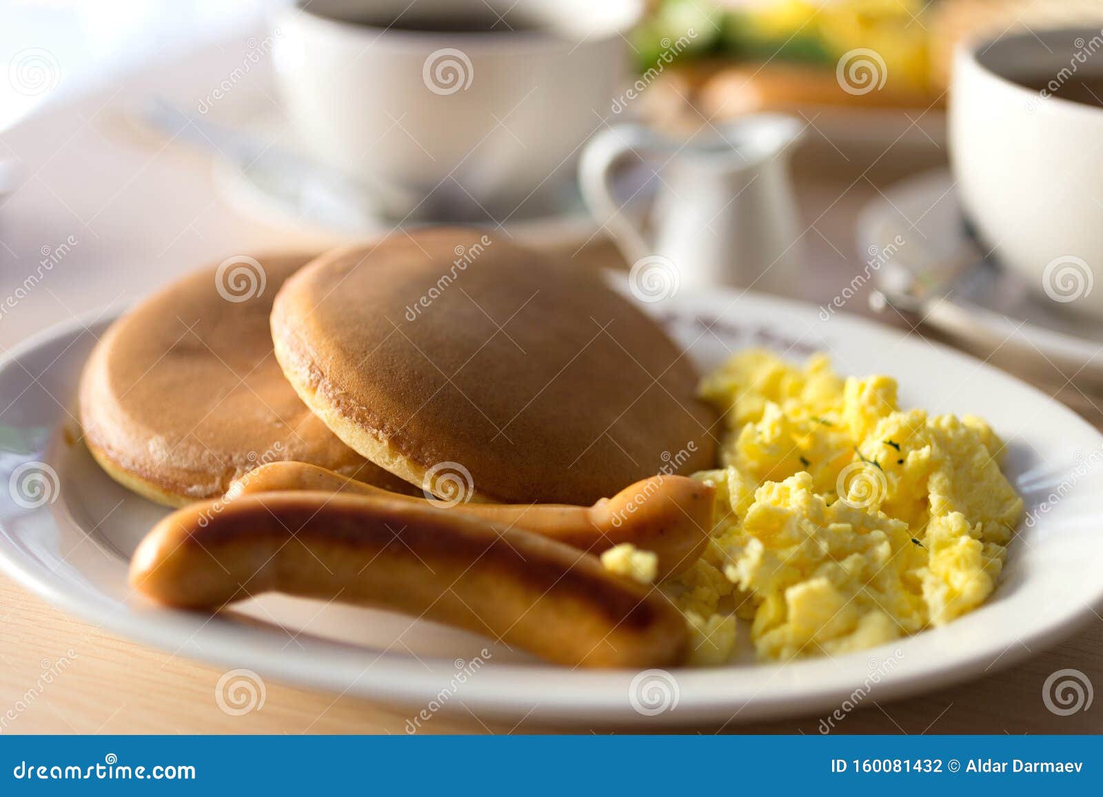 Close Up Breakfast with Sausages, Bread, Scrambled Eggs and Pancakes on
