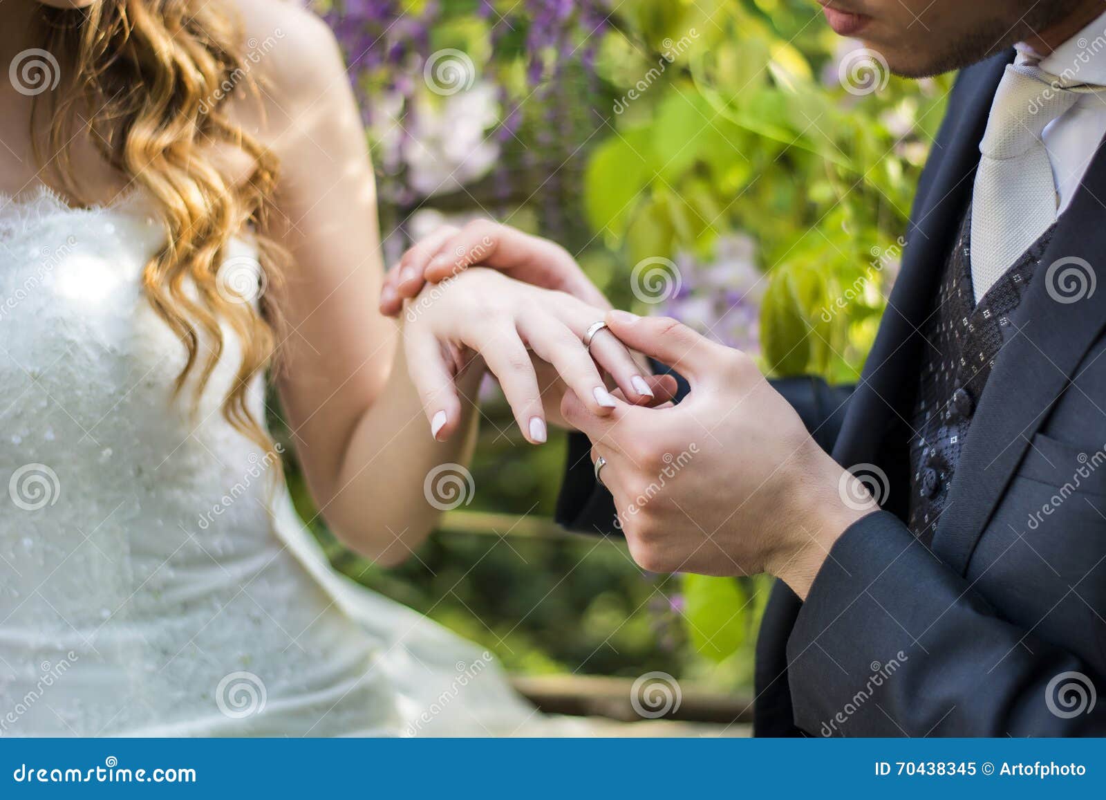 Close Up Of Bridegroom Wearing Wedding Ring On Bride S Finger Stock
