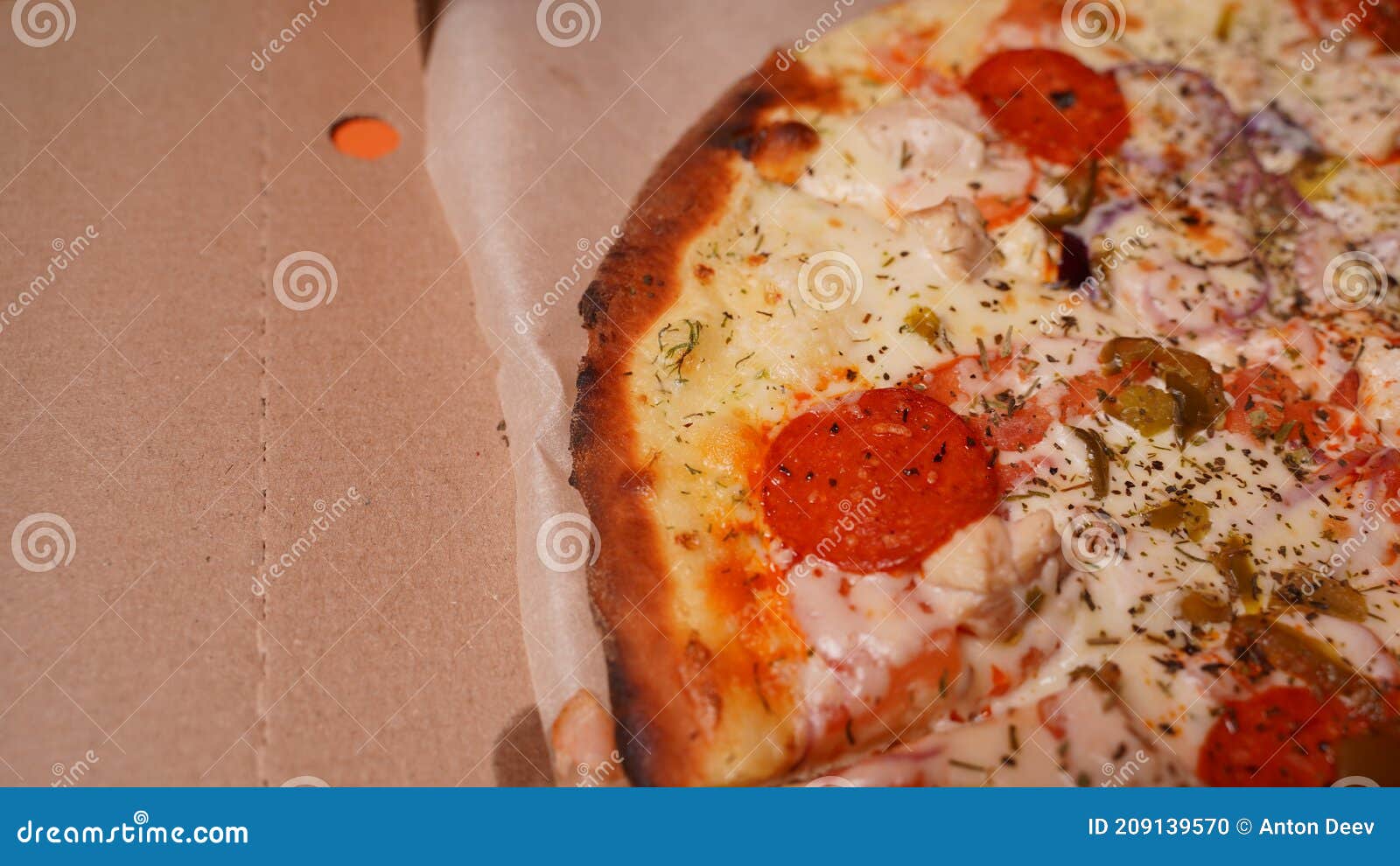 Close Up of Burnt Pizza with Different Ingredients in Box. Appetizing Pizza with Burnt Edge