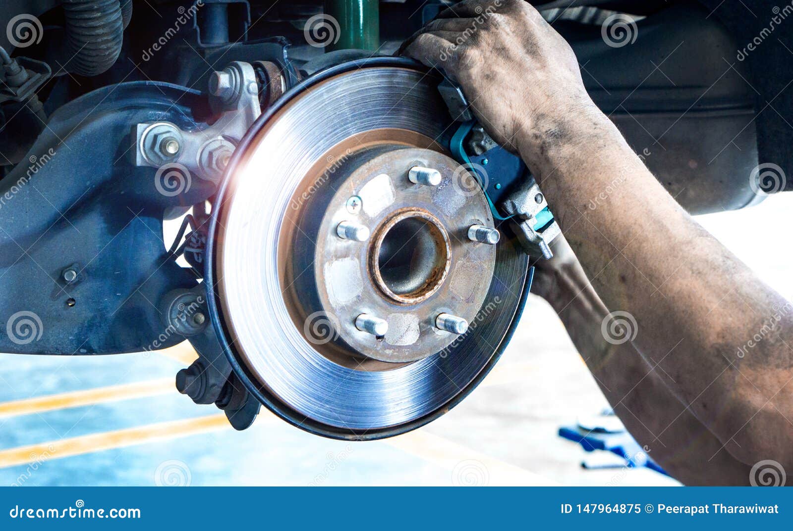 close up car disk brake pad replacement service  with hand of mechanic man in car garage and copy space, use for disk brake