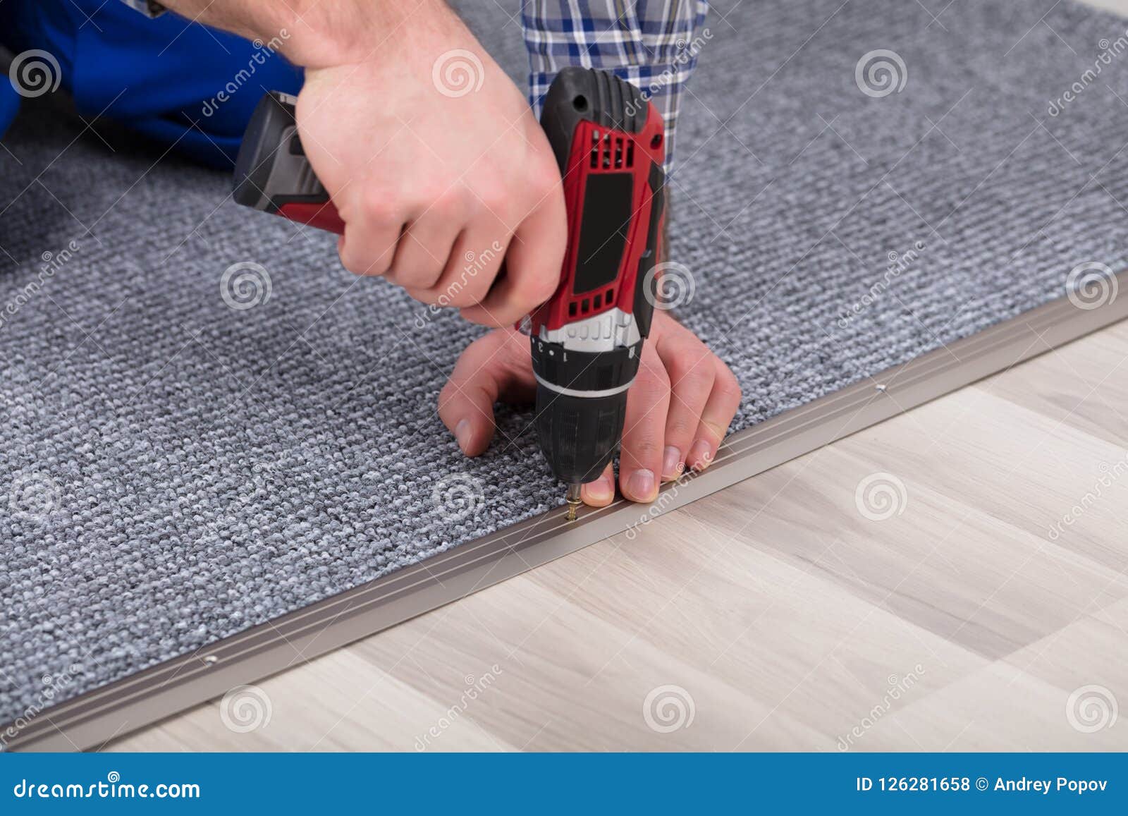 carpet fitter installing carpet with wireless screwdriver