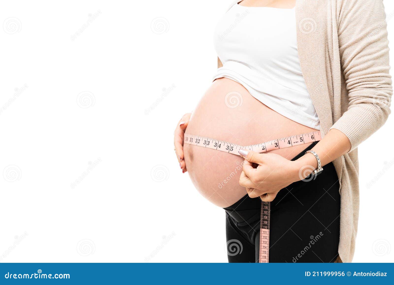 pregnant woman measuring her belly. Closeup female pregnant belly