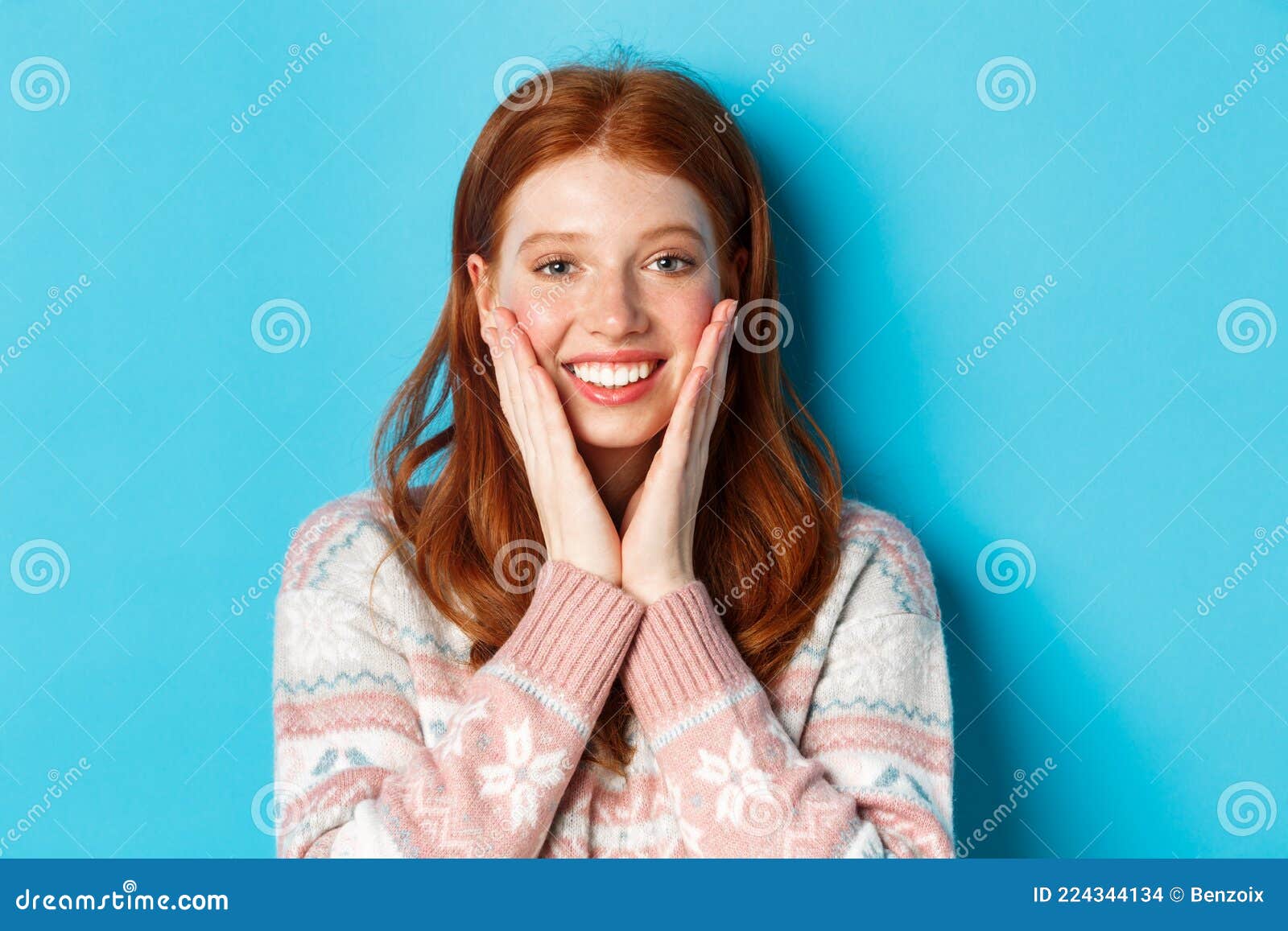 Close Up Of Cheerful Redhead Girl Blushing Touching Cheeks And Smiling 