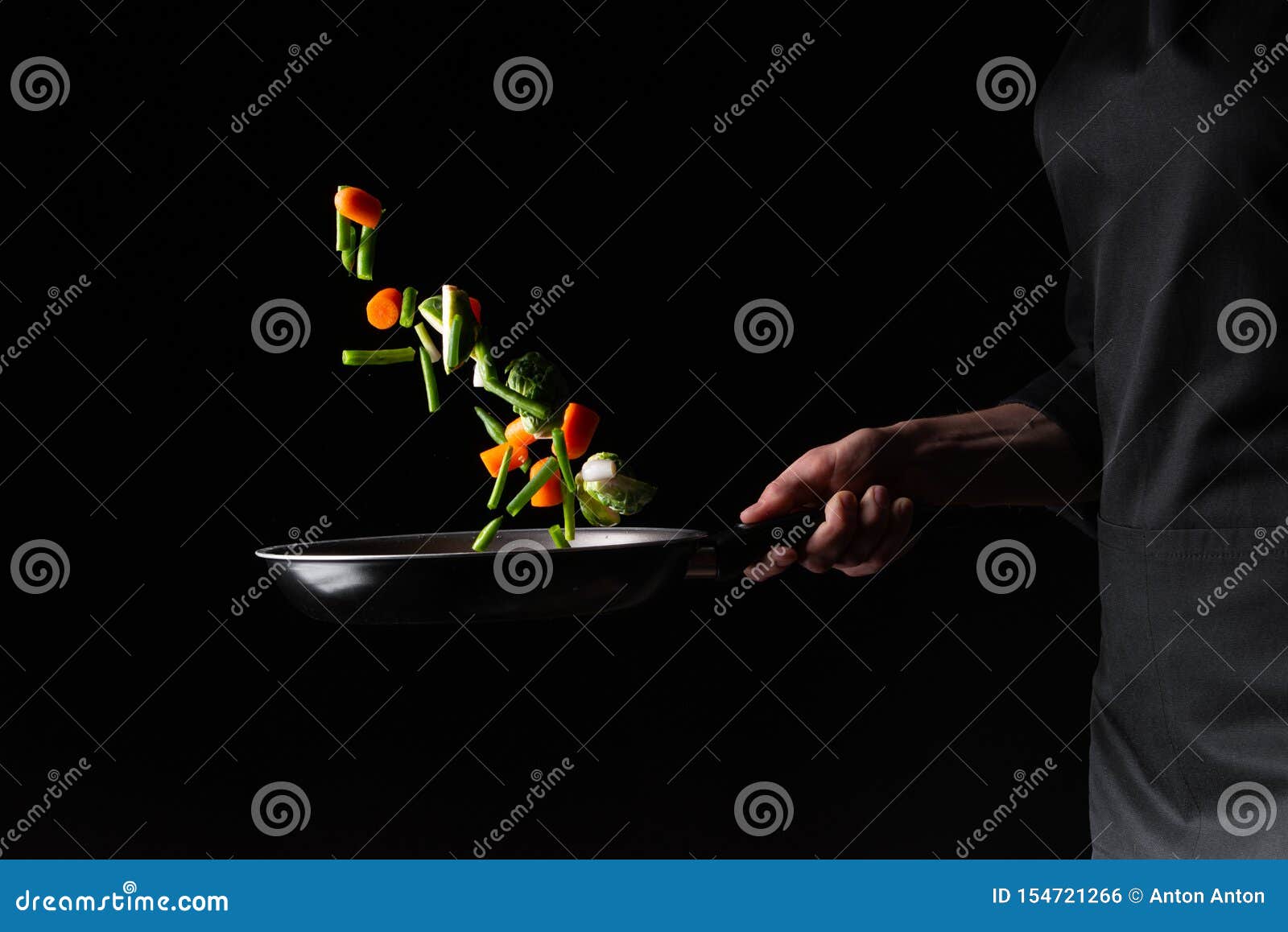 close-up, chef preparing vegetables in a skillet frying them. hotel business and the menu in restaurants, the book of recipes. on