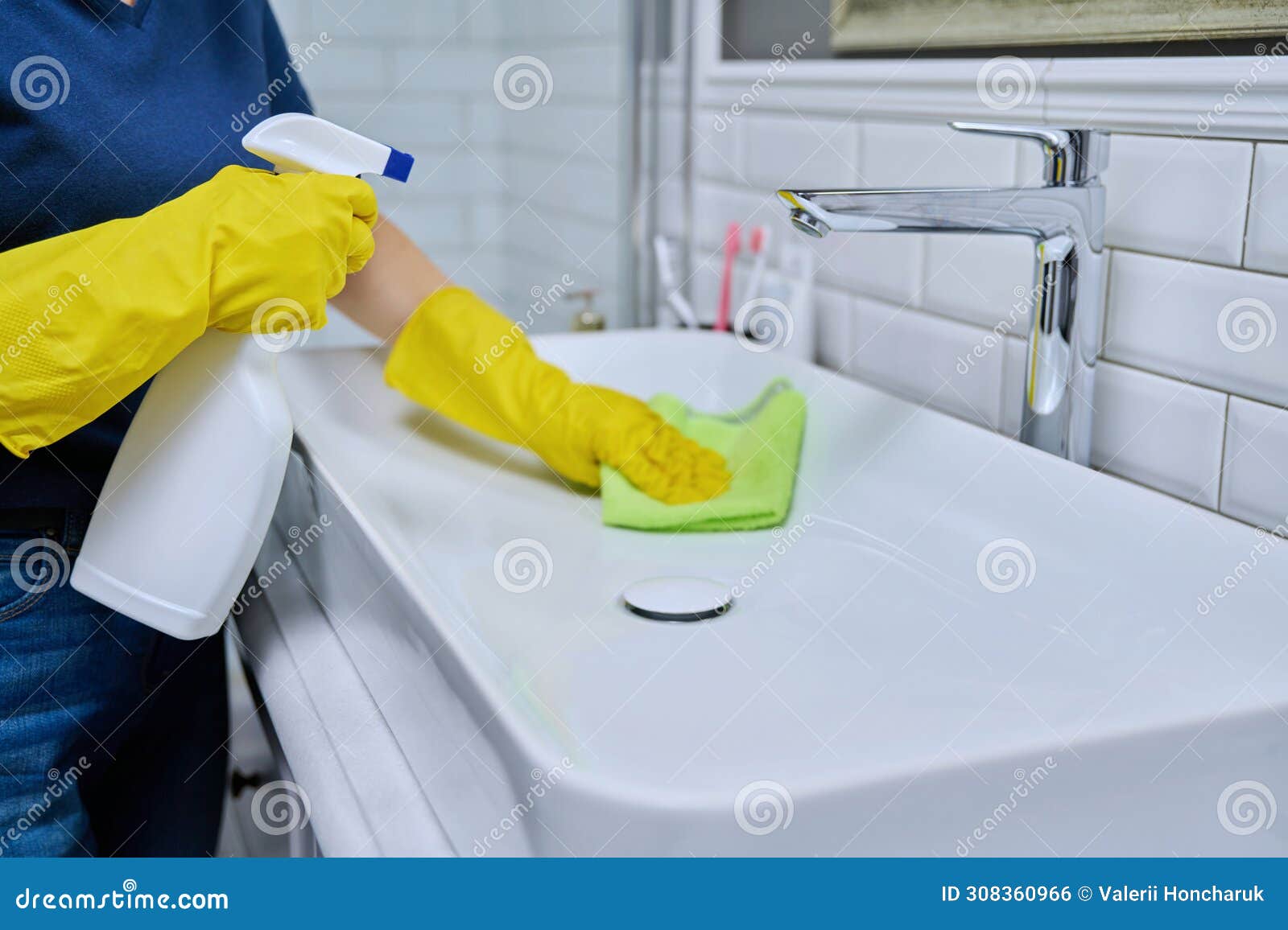 close-up of cleaning sink with faucet in bathroom, hands in gloves with detergent