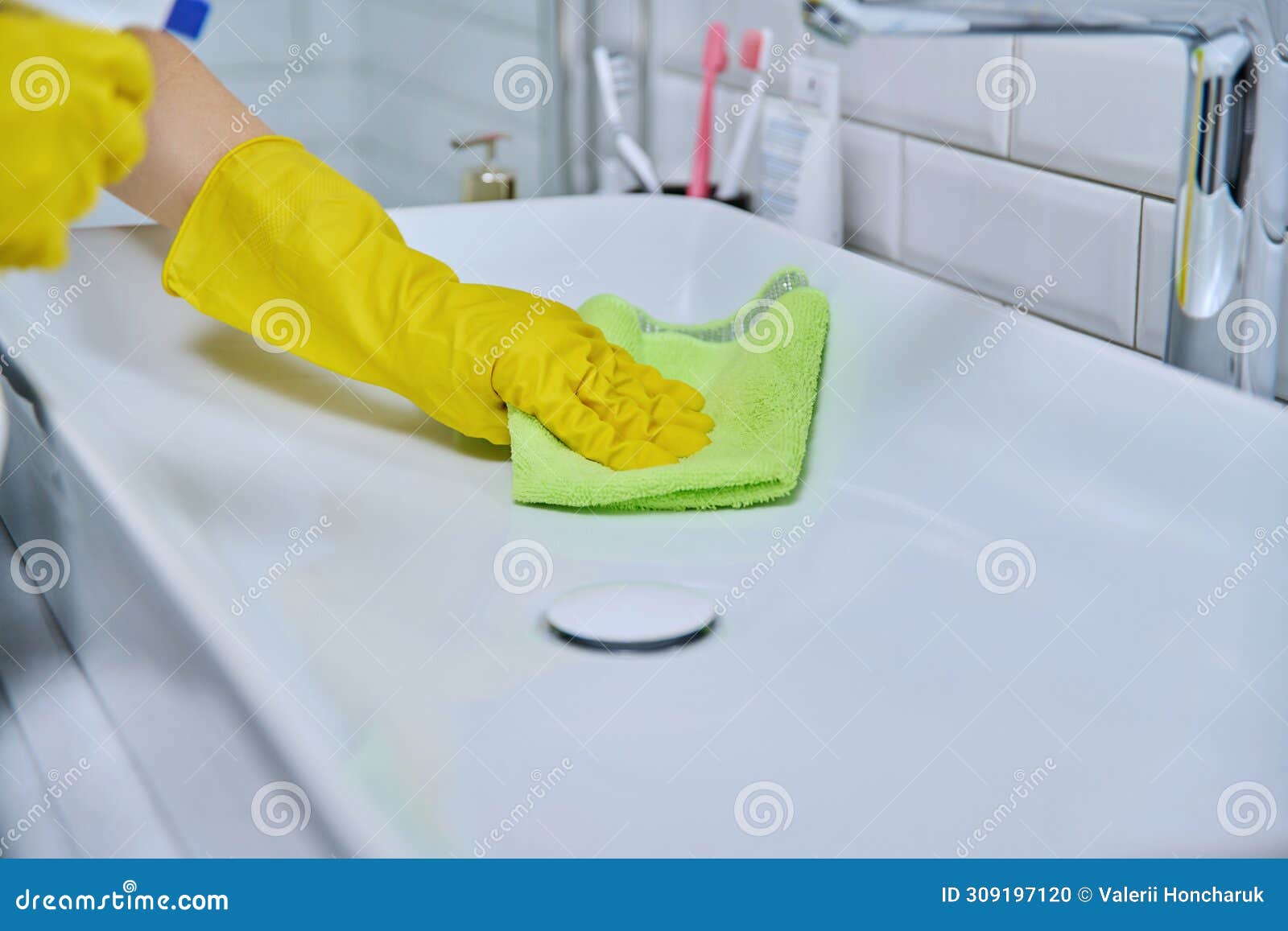 close-up of cleaning sink with faucet in bathroom, hands in gloves with detergent