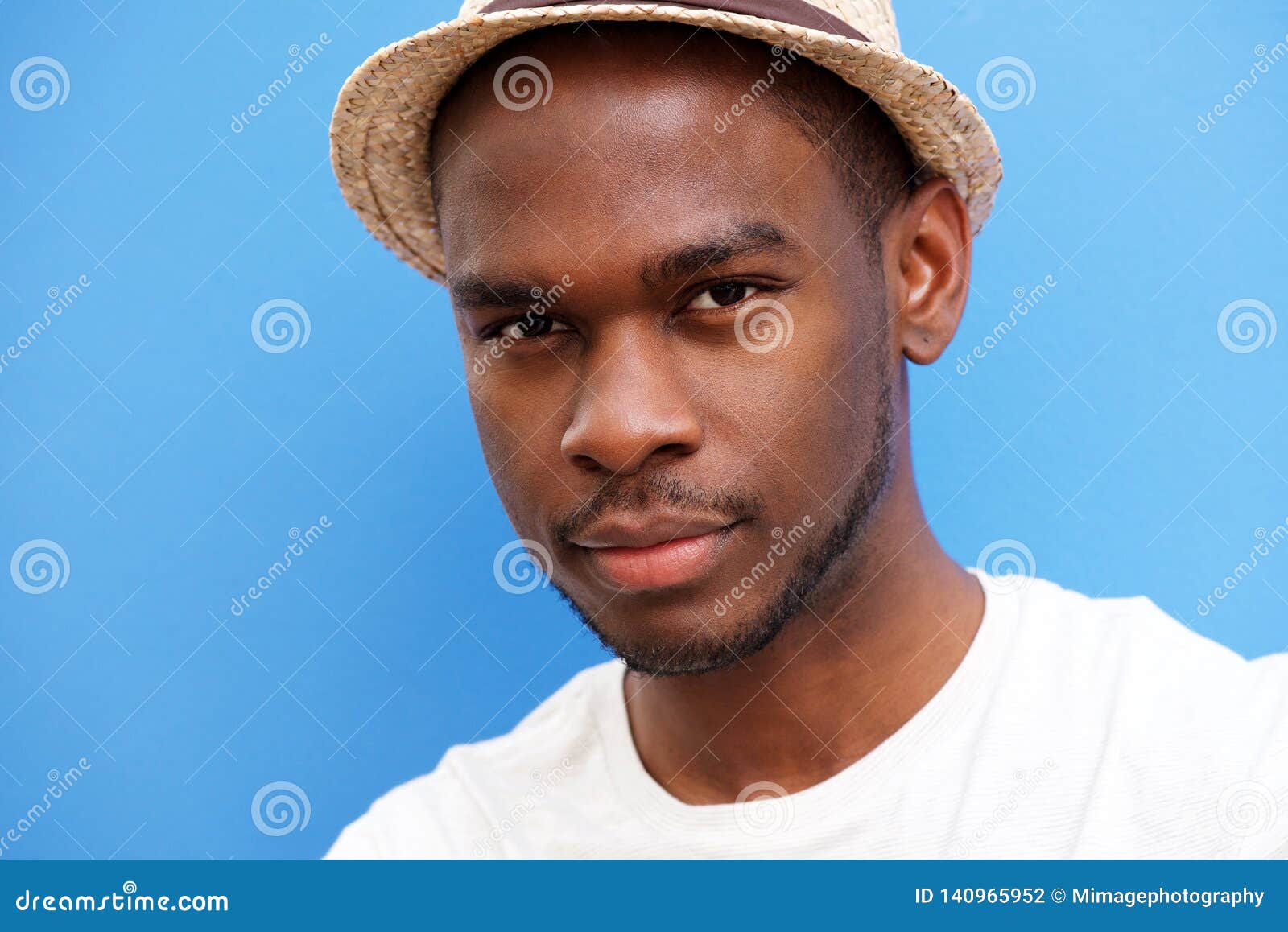 Close Up Cool Young Black Guy with Hat Against Blue Background Stock
