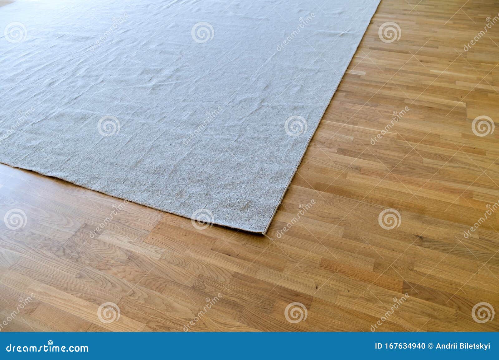 Close Up Of Crumpled Carpet Laying On Parquet Wooden Floor Stock
