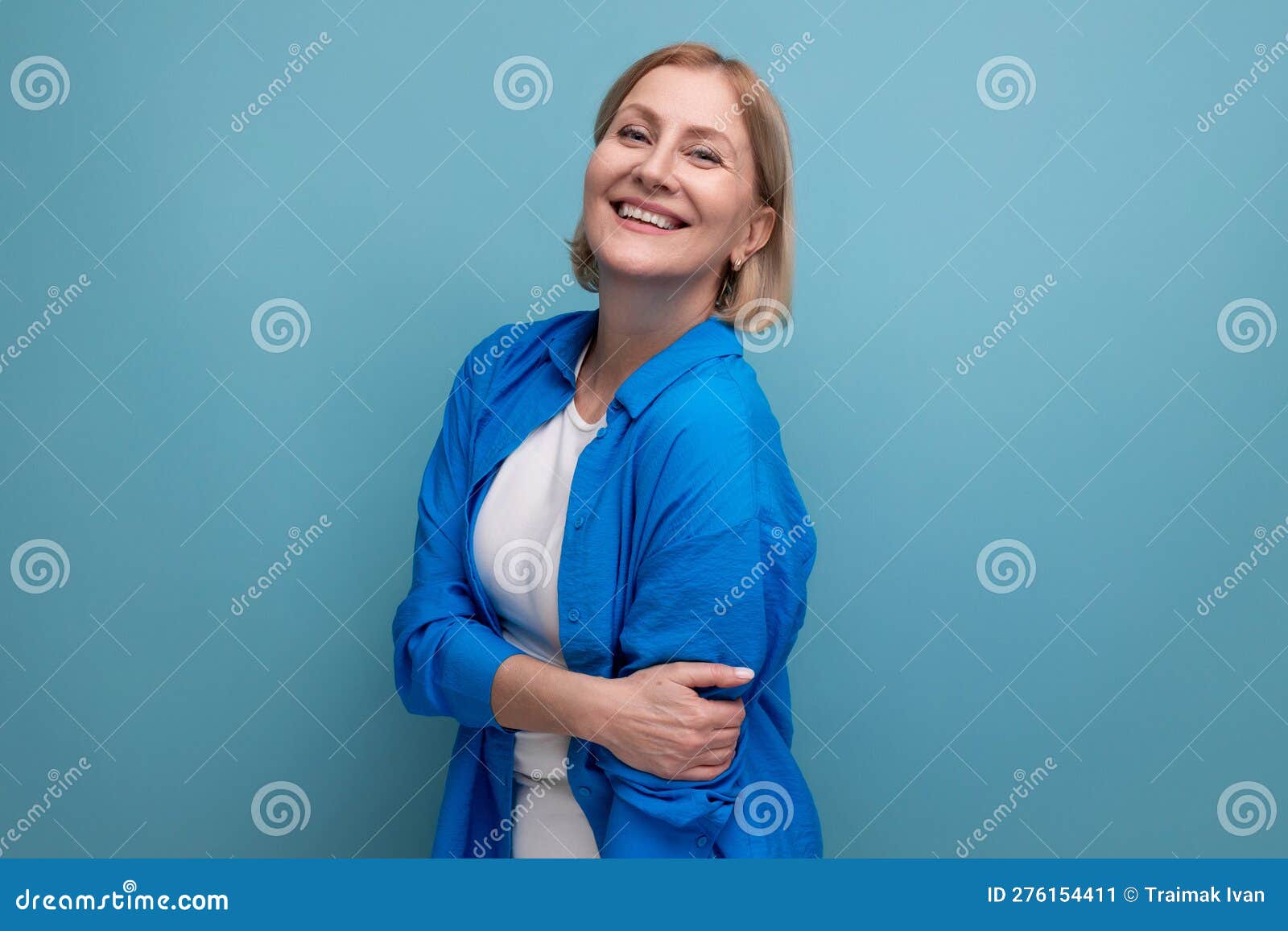 Close Up Of A Cute Mature Woman In A Shirt On A Blue Background With Copyspace Stock Image