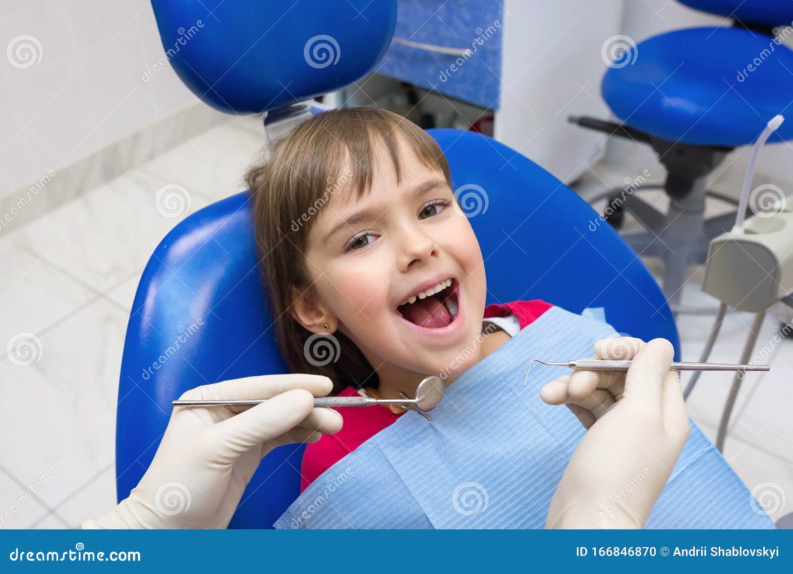 a close-up of a dentistÃ¢â¬â¢s hands and a child with an opened mouth