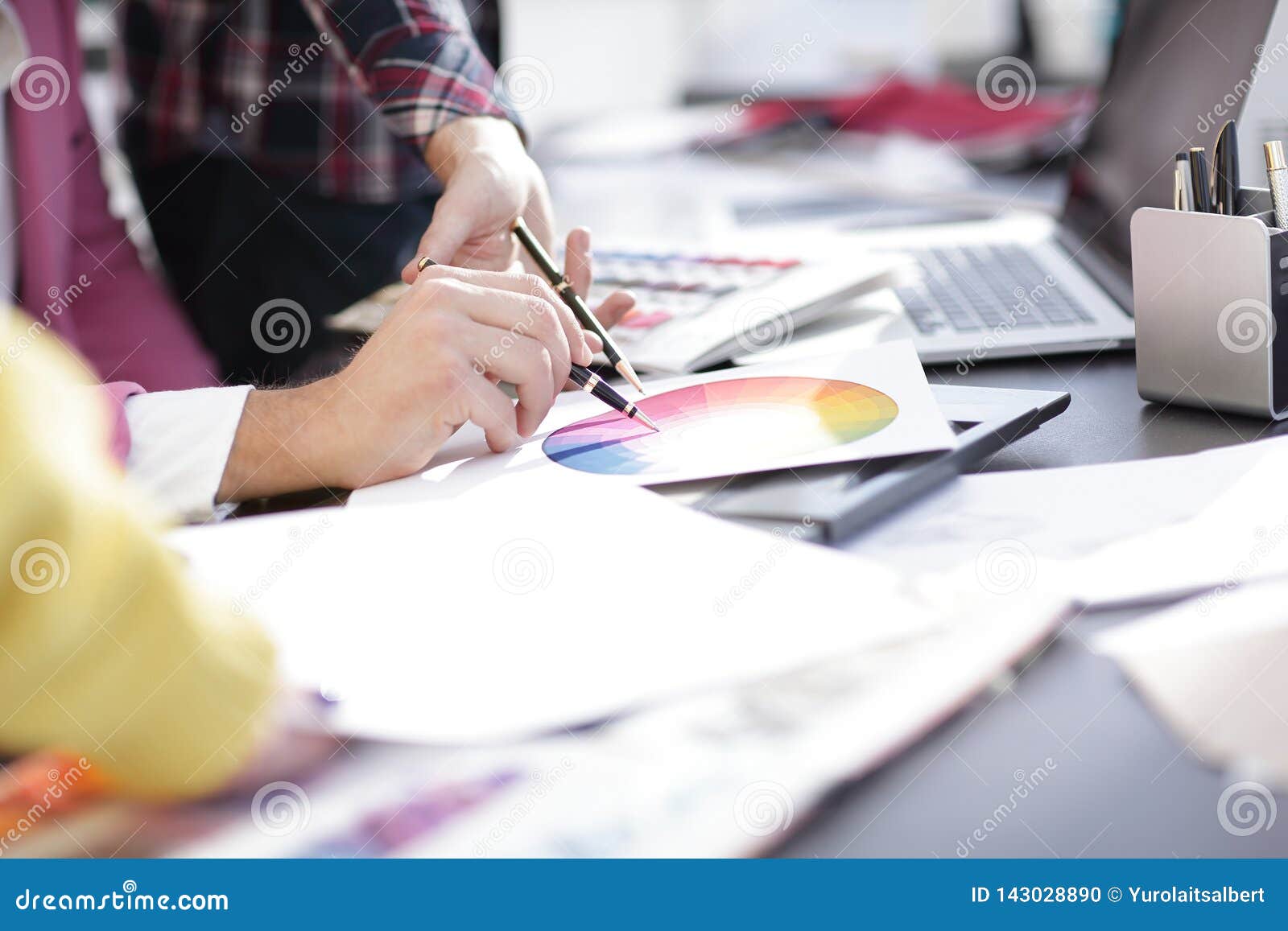 Close Up Designer Working At Office Desk With Blueprints For A New