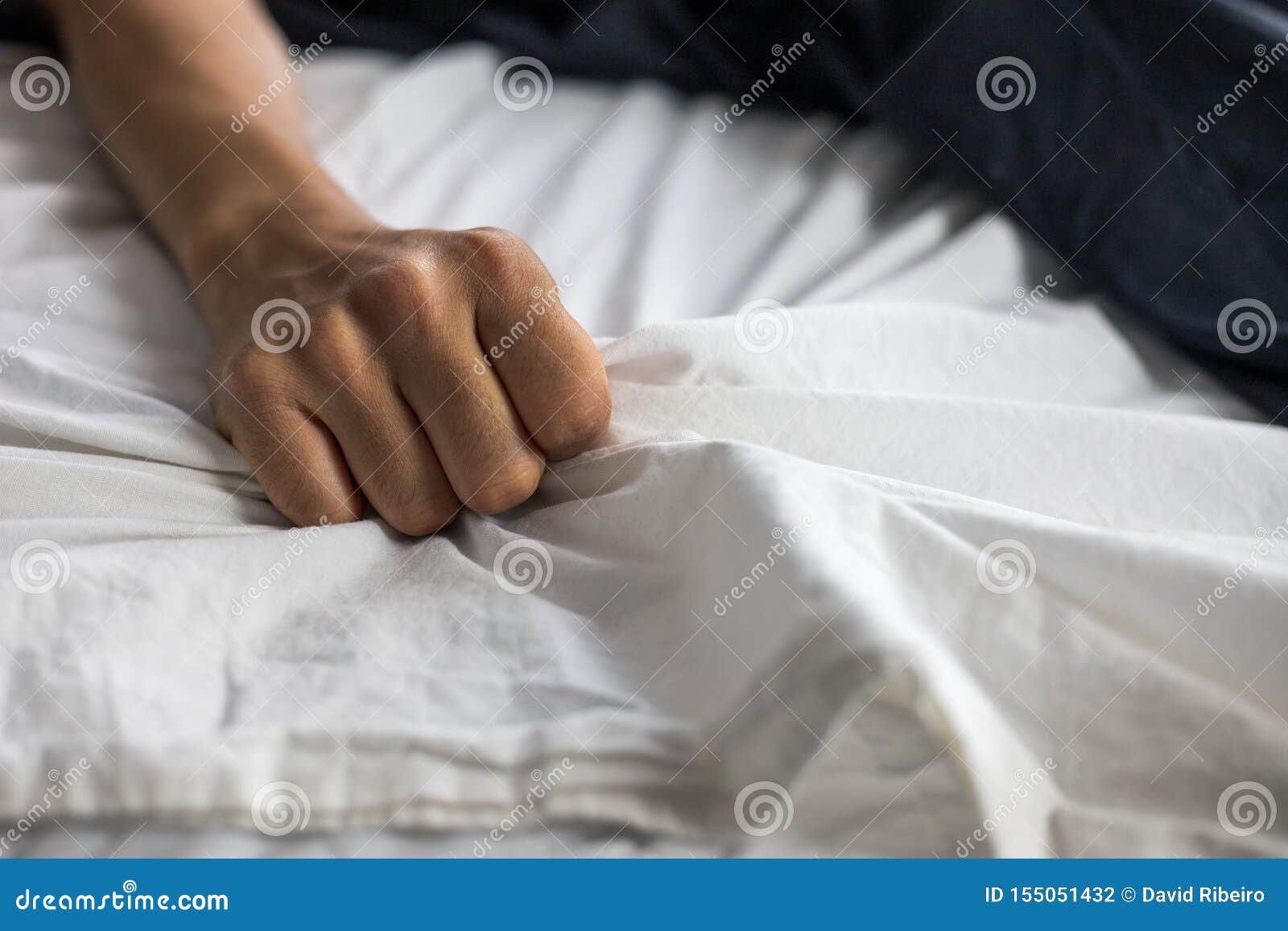 Close Up Detail Of A Womens Hand Grabbing On To The Bed Sheets