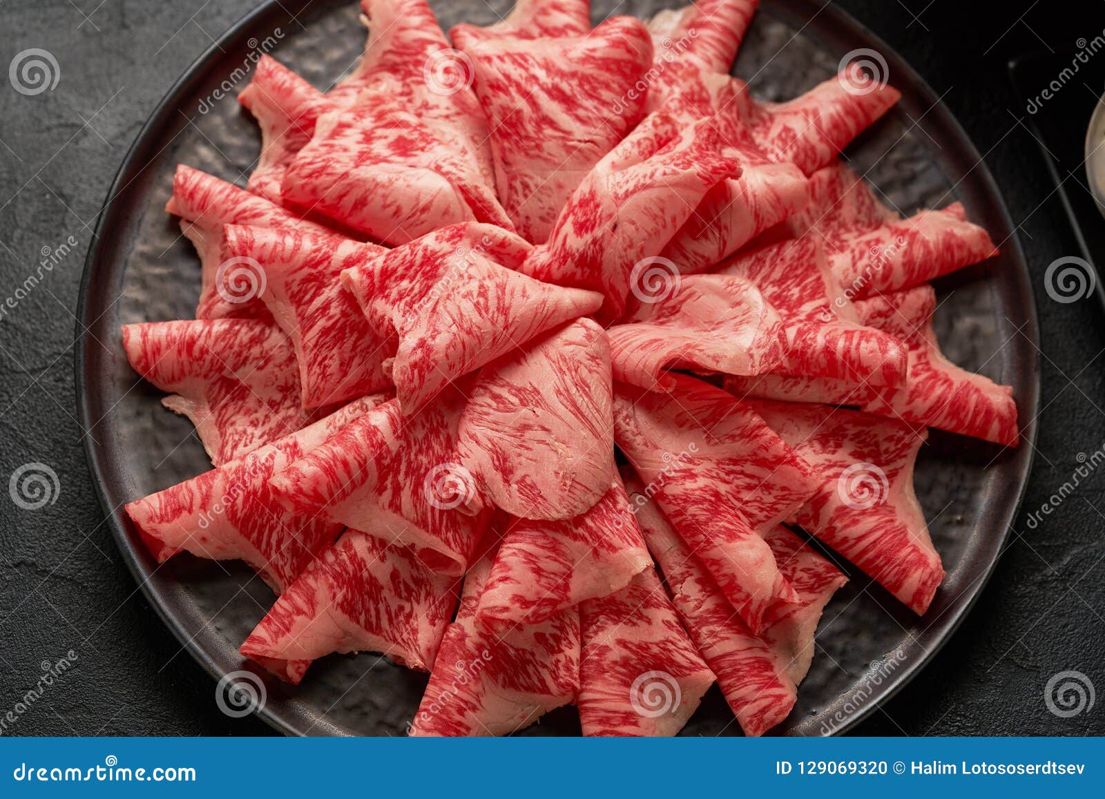 a close up detailed image of sliced japanese wagyu beef in a ceramic plate prepared for shabu shab