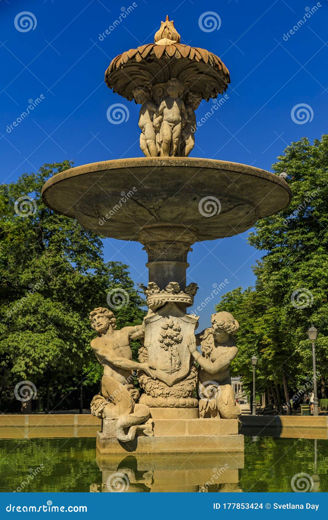 details of the artichoke fountain or fuente de la alcachofa with triton and nereida in buen retiro park, madrid, spain