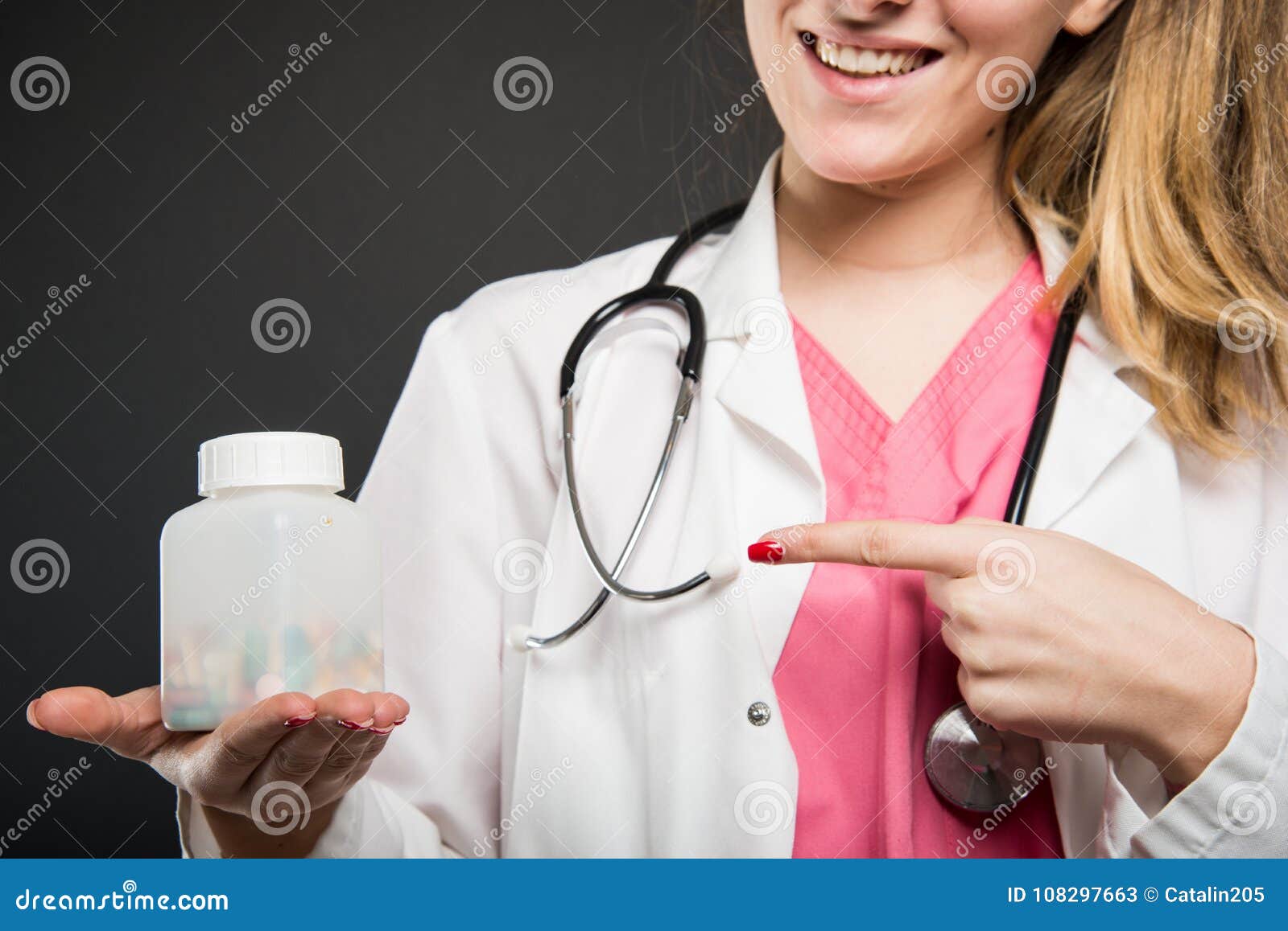 Close-up do doutor fêmea que aponta a garrafa dos comprimidos no fundo preto com o copyspace que anuncia a área