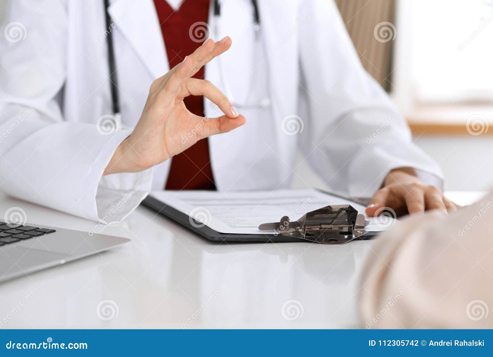 Close Up Of A Doctor Hand Showing Ok Sign While Phusician And His Patient Discussing Medical