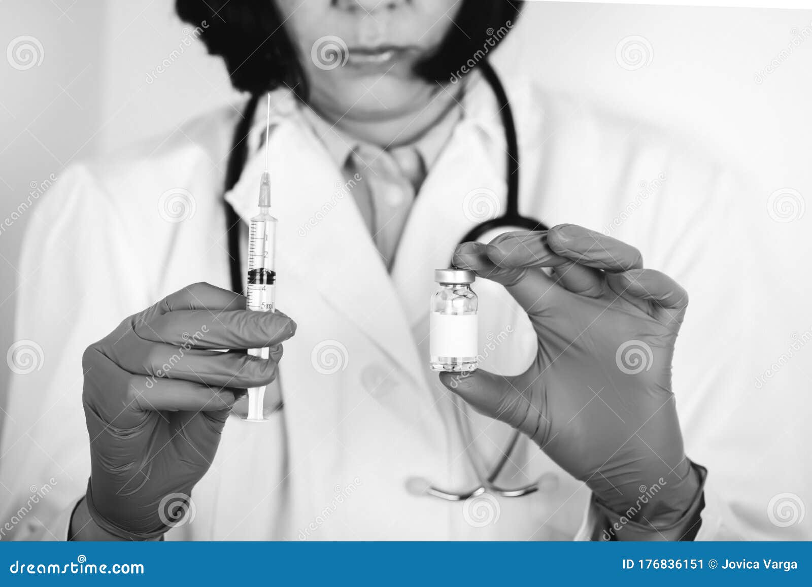 close up of a doctor in white lab coat and sterile gloves holding syringe and medicine in ampoule
