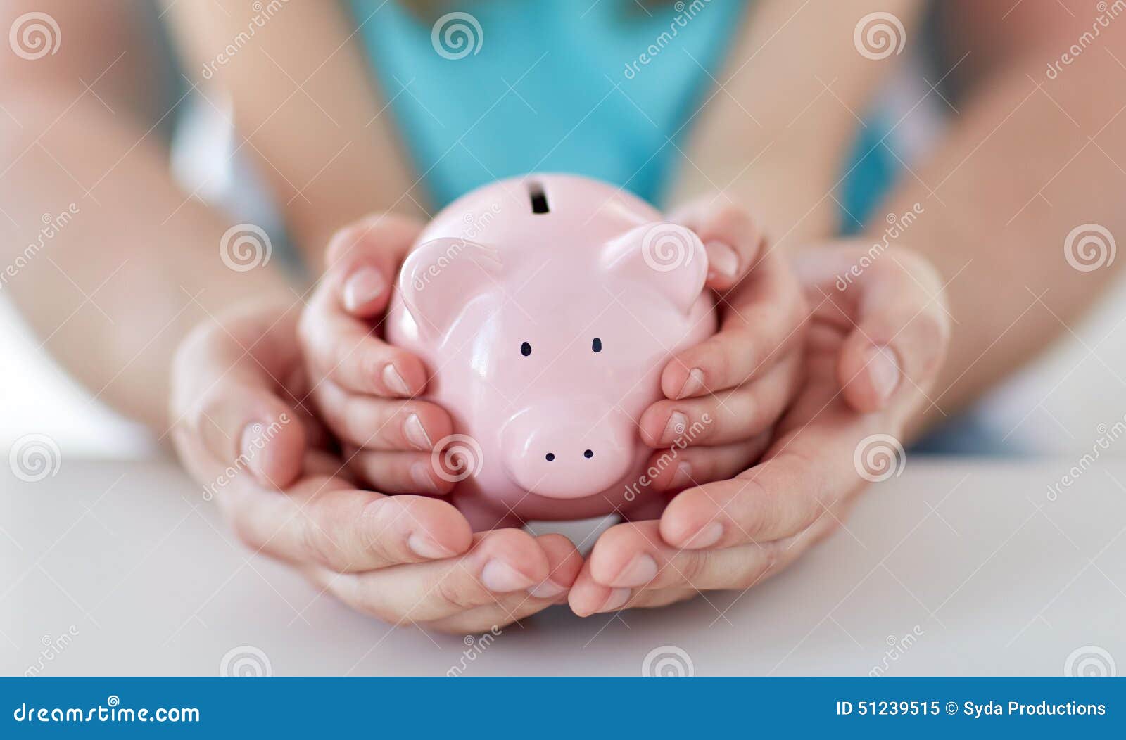 close up of family hands with piggy bank