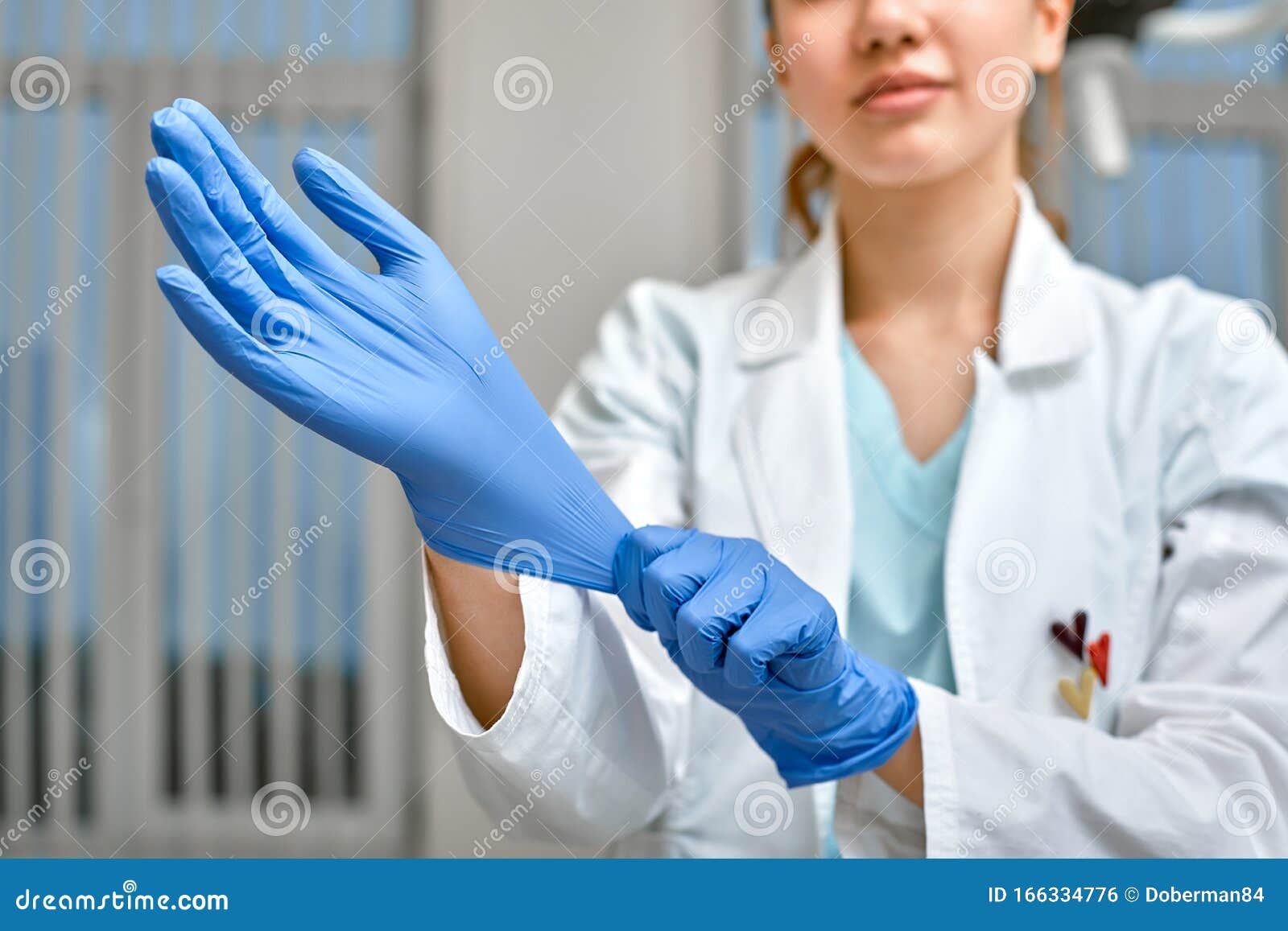 Close Up Of A Female Doctor Putting A Blue Latex Gloves On A Clinic