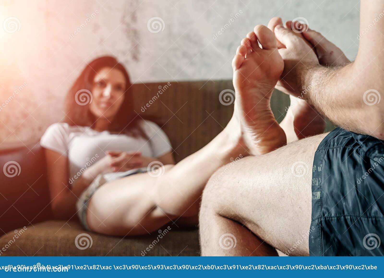 Close-up of Female Legs Receiving a Foot Massage from Her Husband photo