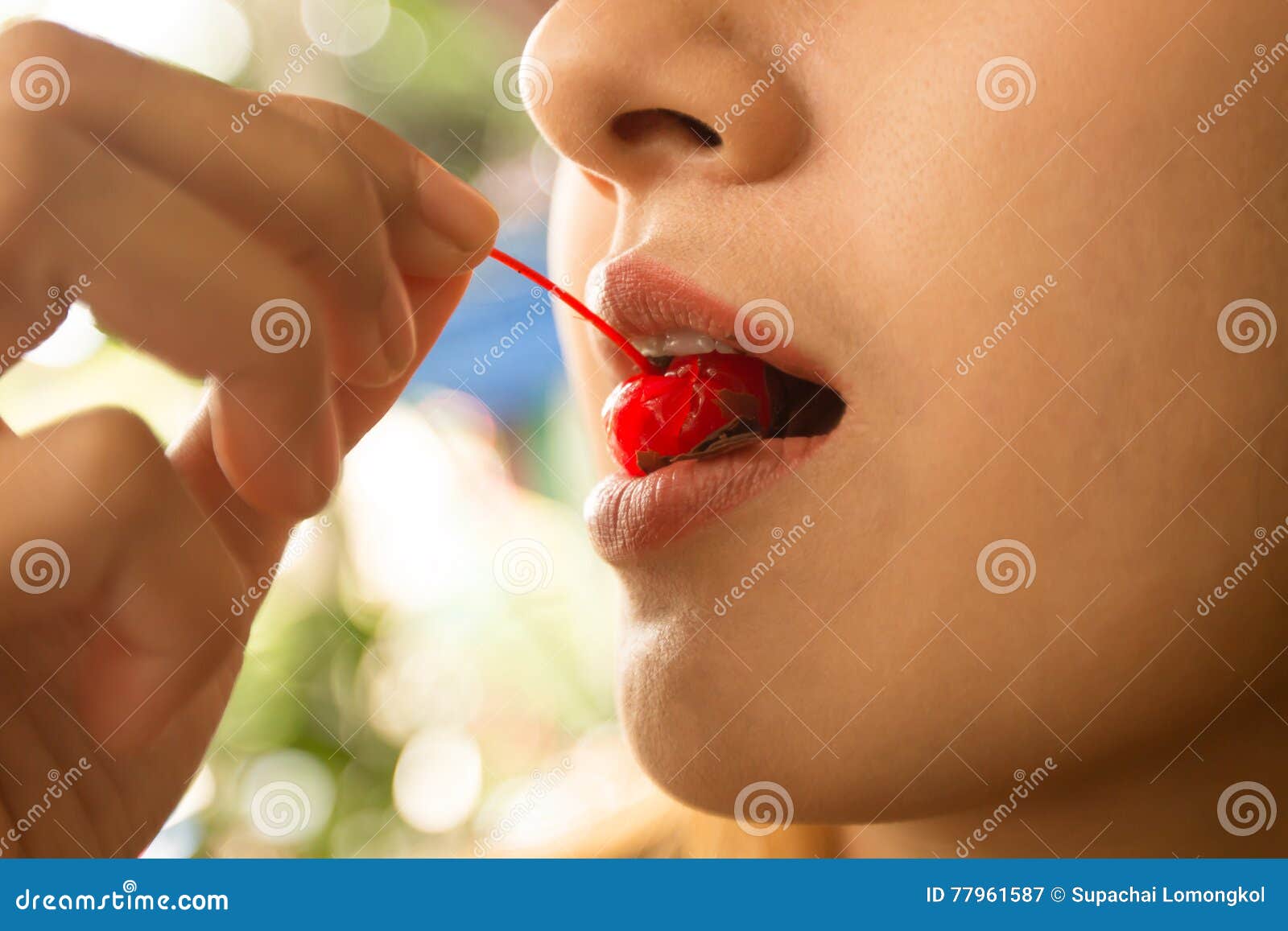 Close Up Of Female Mouth With Pink Lips Bite On A Cherry